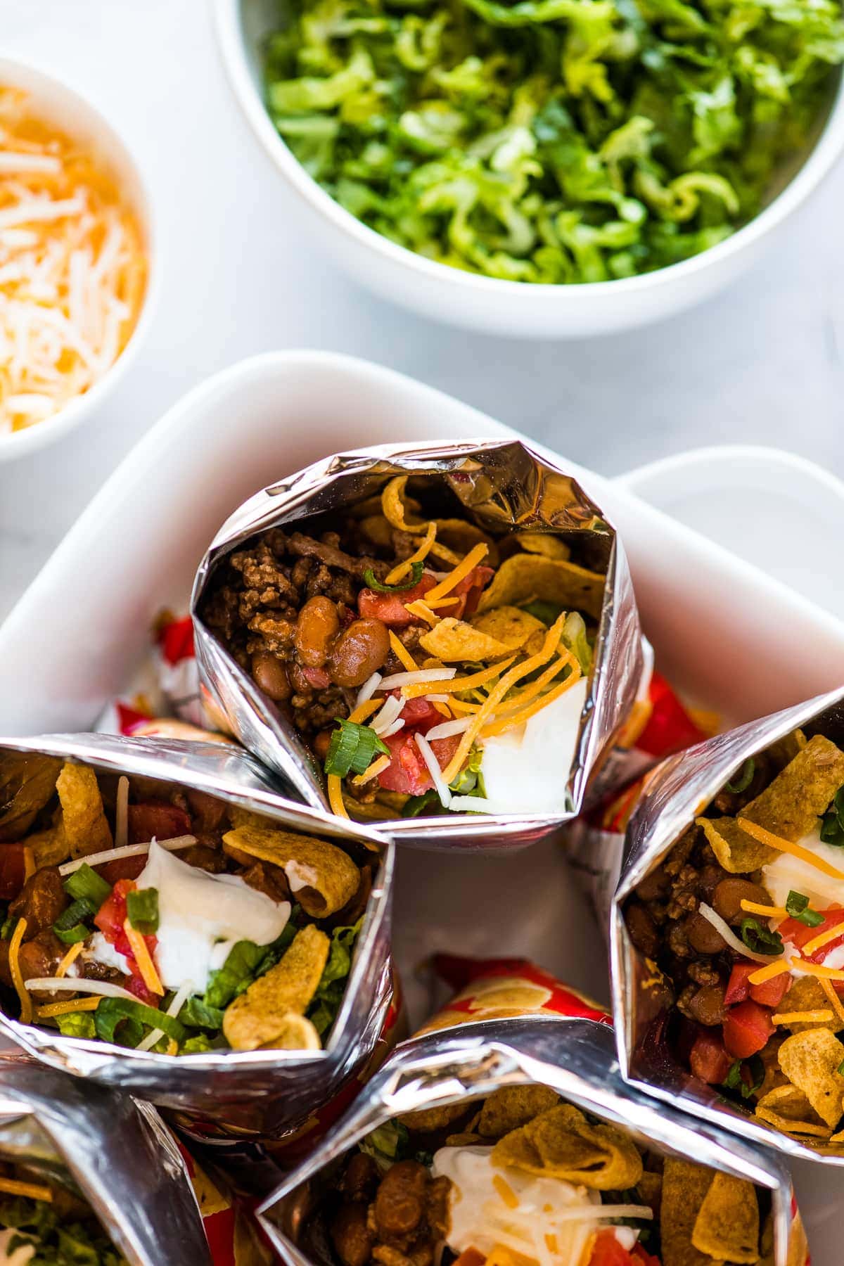 Bags of walking tacos filled with beef, beans, cheese, sour cream, tomatoes, and more.