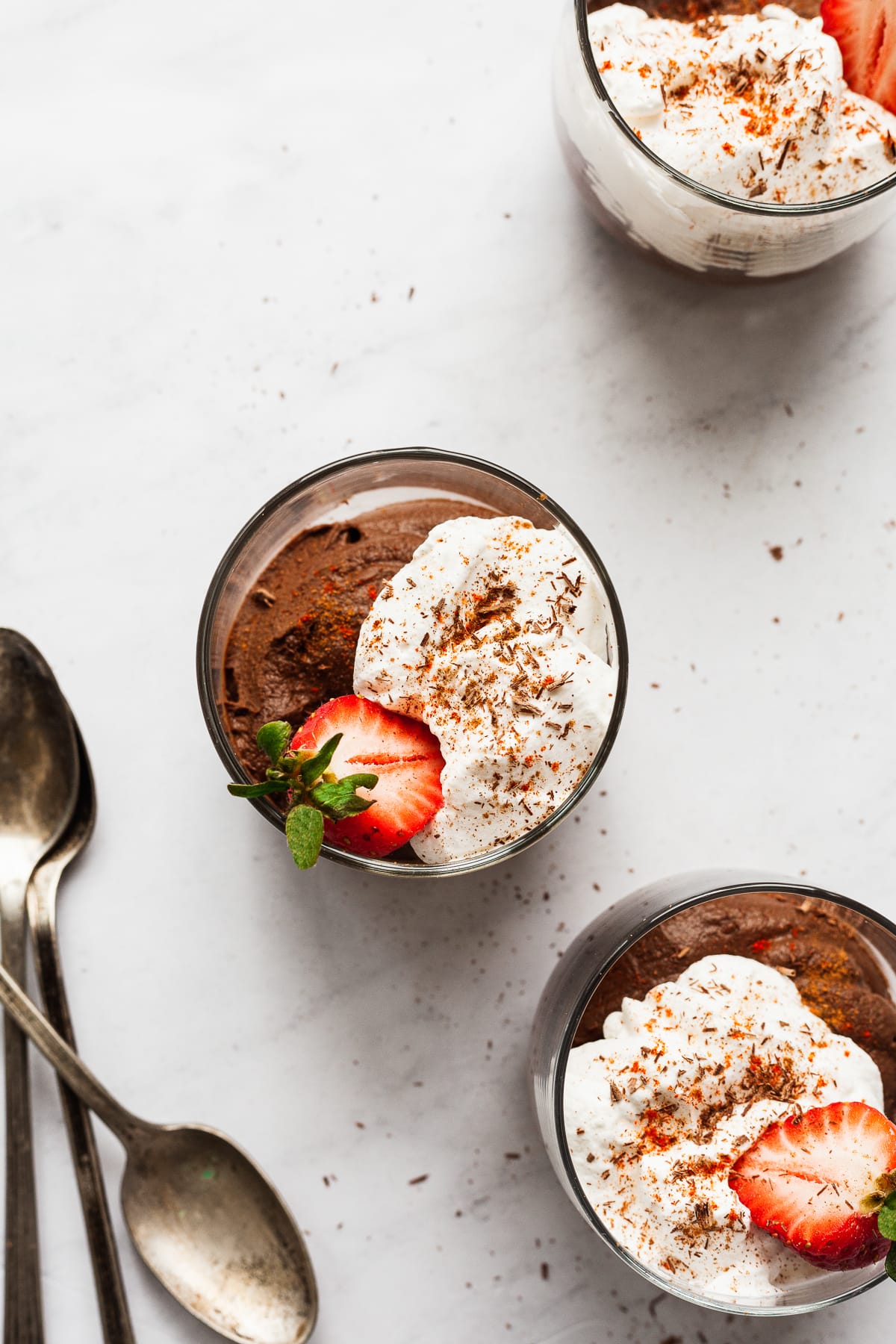 Avocado chocolate mousse in 3 cups on a table.