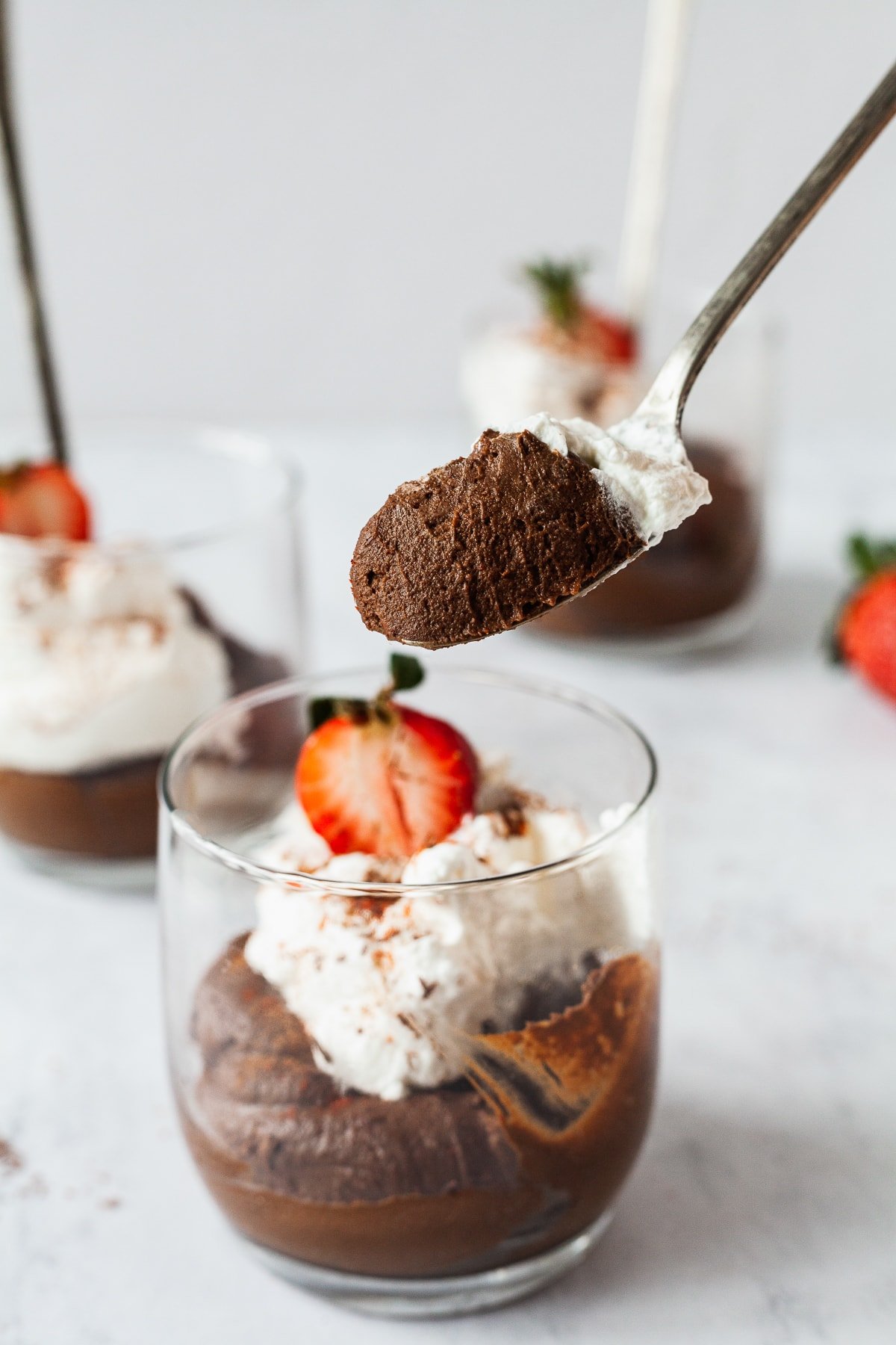 A spoon filled with a scoop of avocado chocolate mousse.