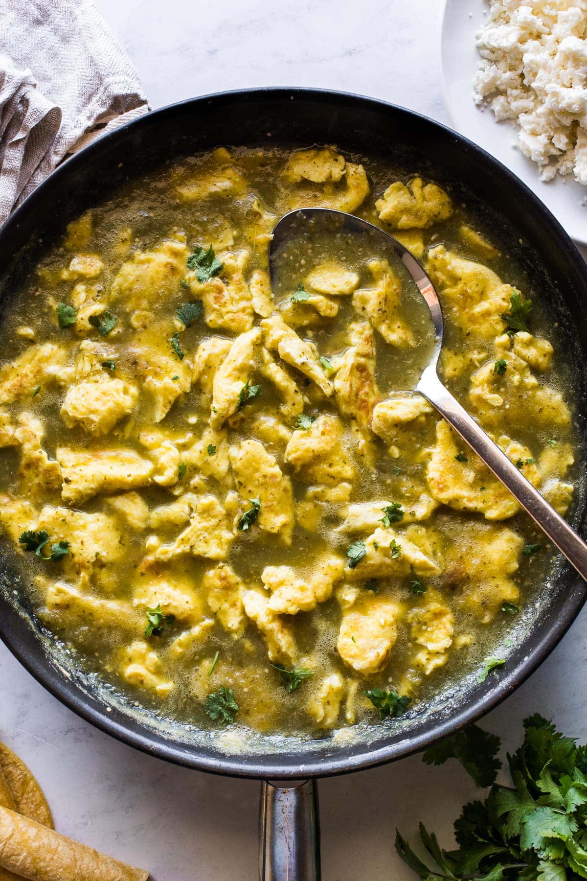 Huevo en chile verde (or scrambled eggs in a salsa verde) in a skillet.