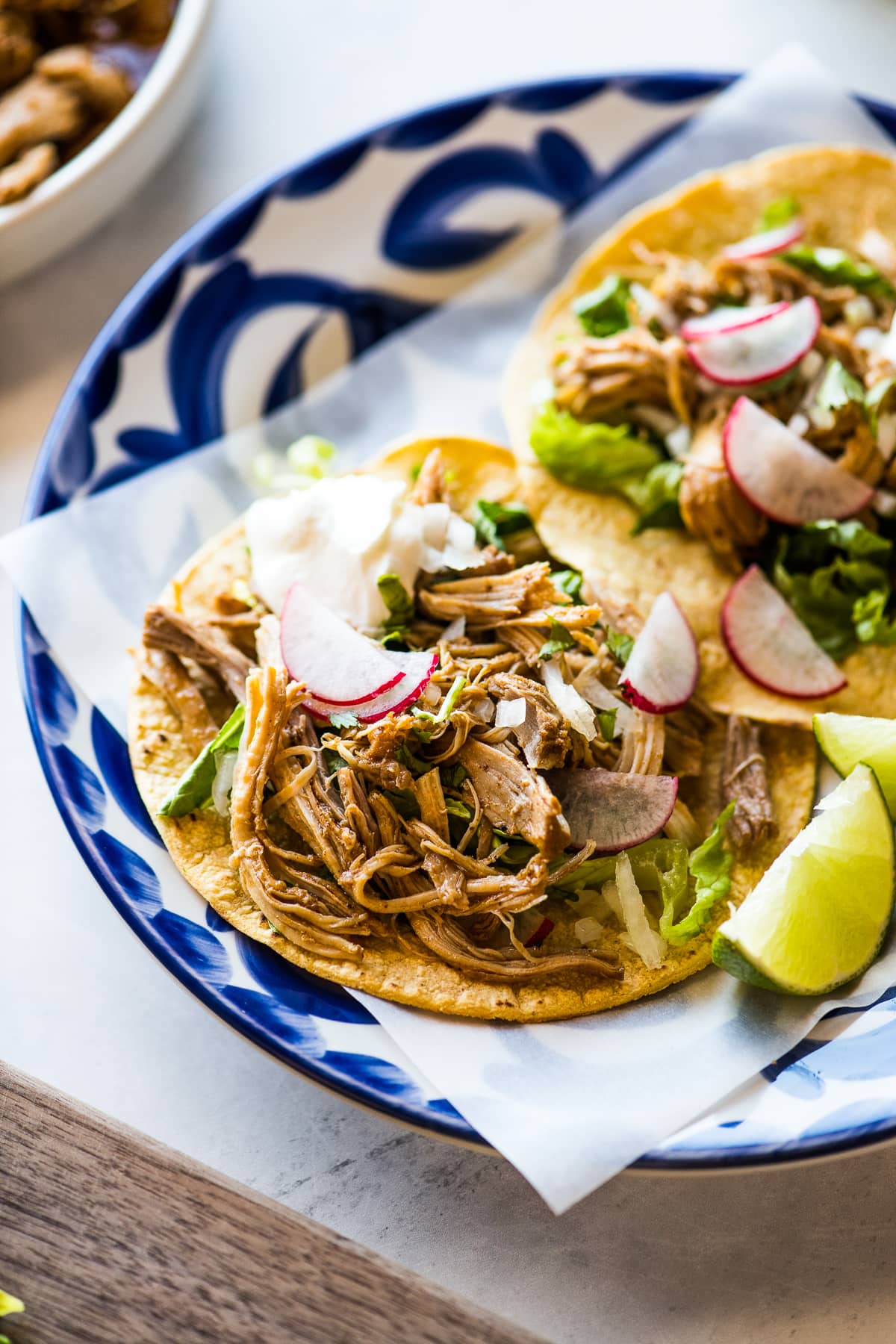 Instant Pot Chicken Tacos topped with sour cream and cilantro on a plate.