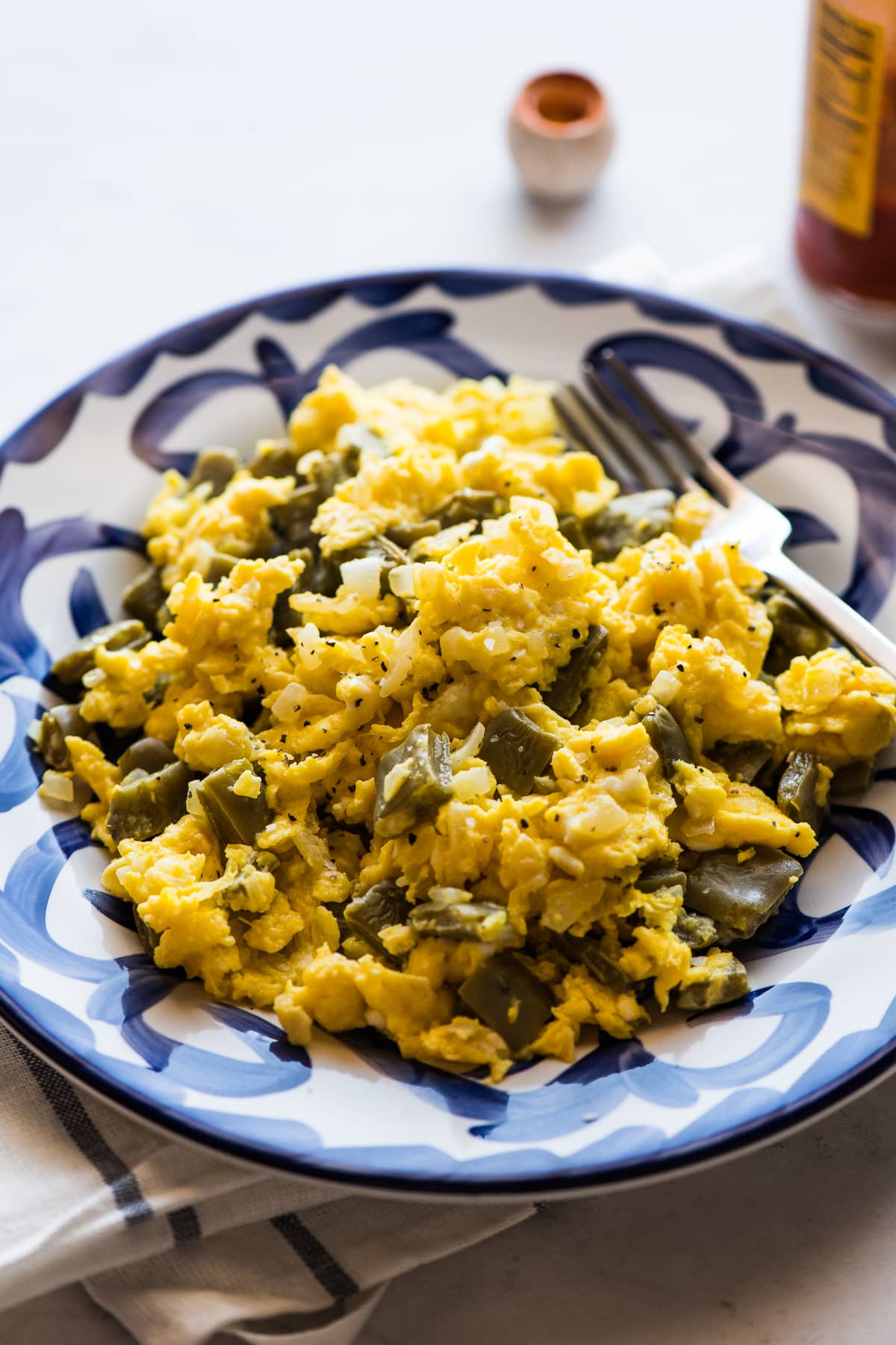 nopales con huevo on a plate garnished with salt and pepper.