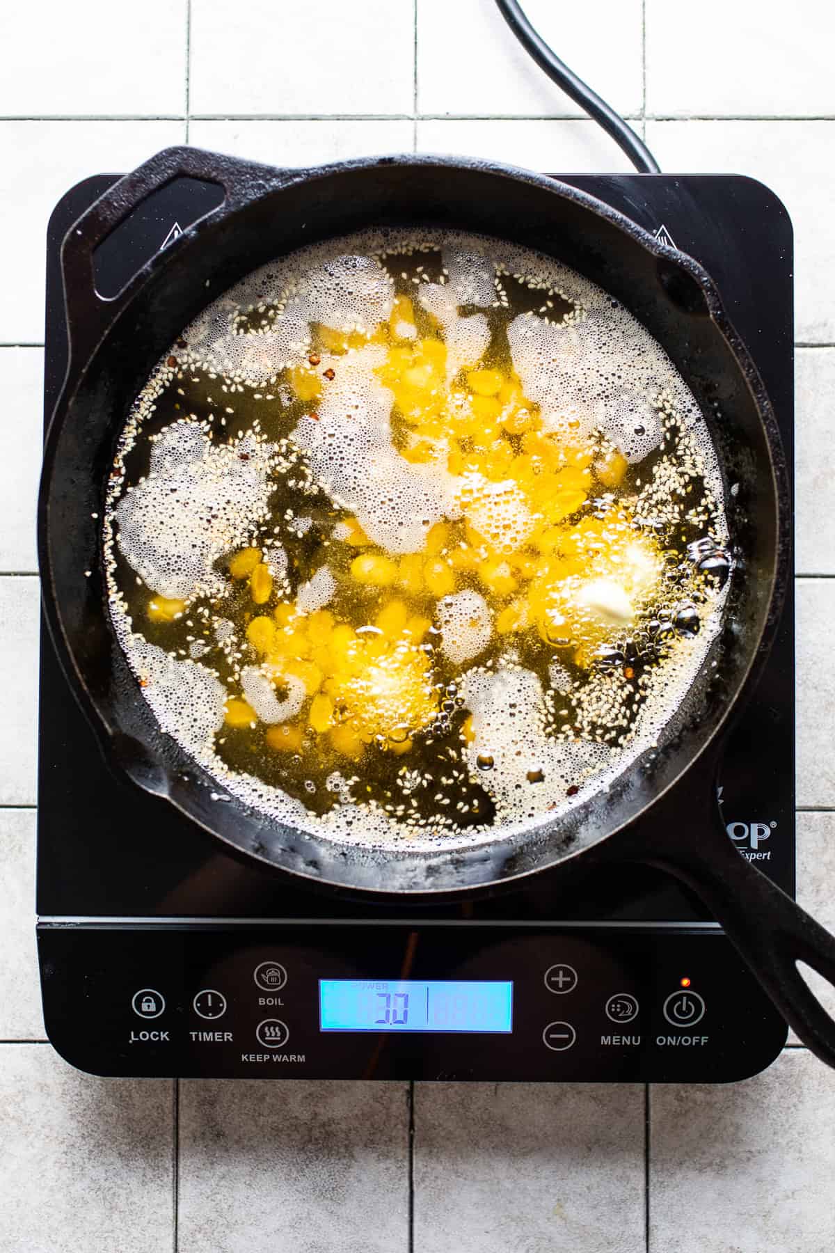 Garlic, peanuts, and sesame seeds frying in oil