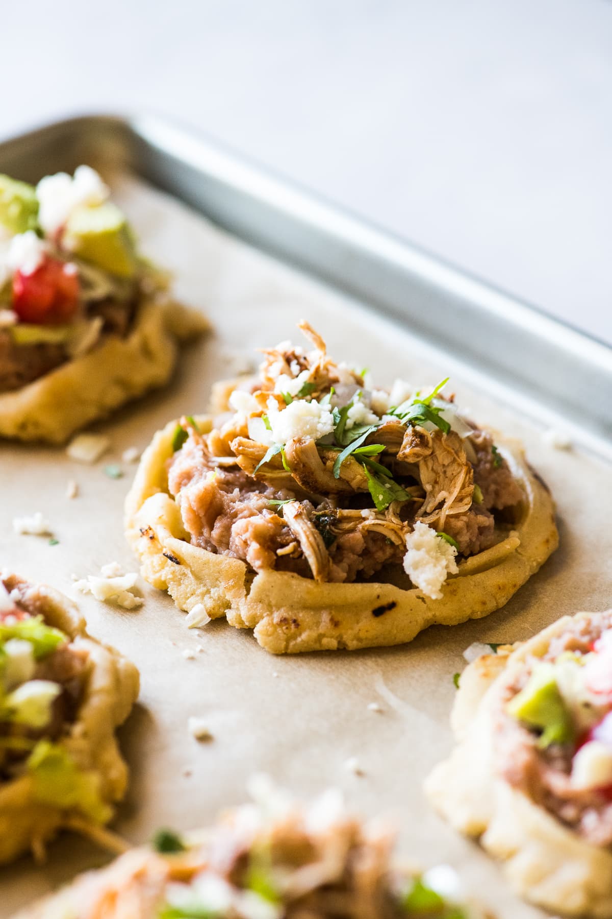 Sopes topped with shredded carnitas and queso fresco.