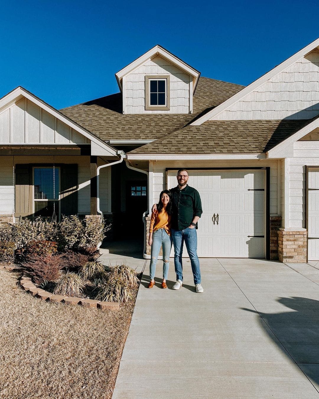 Isabel and John in front of their new house.