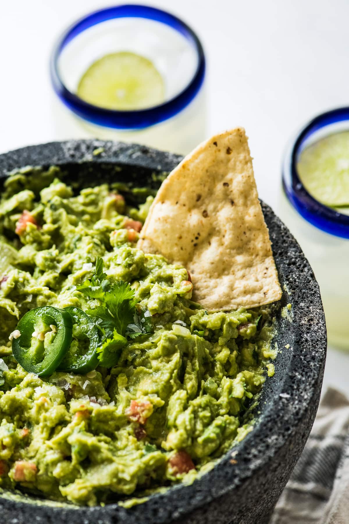 The best guacamole recipe garnished with cilantro and jalapenos.