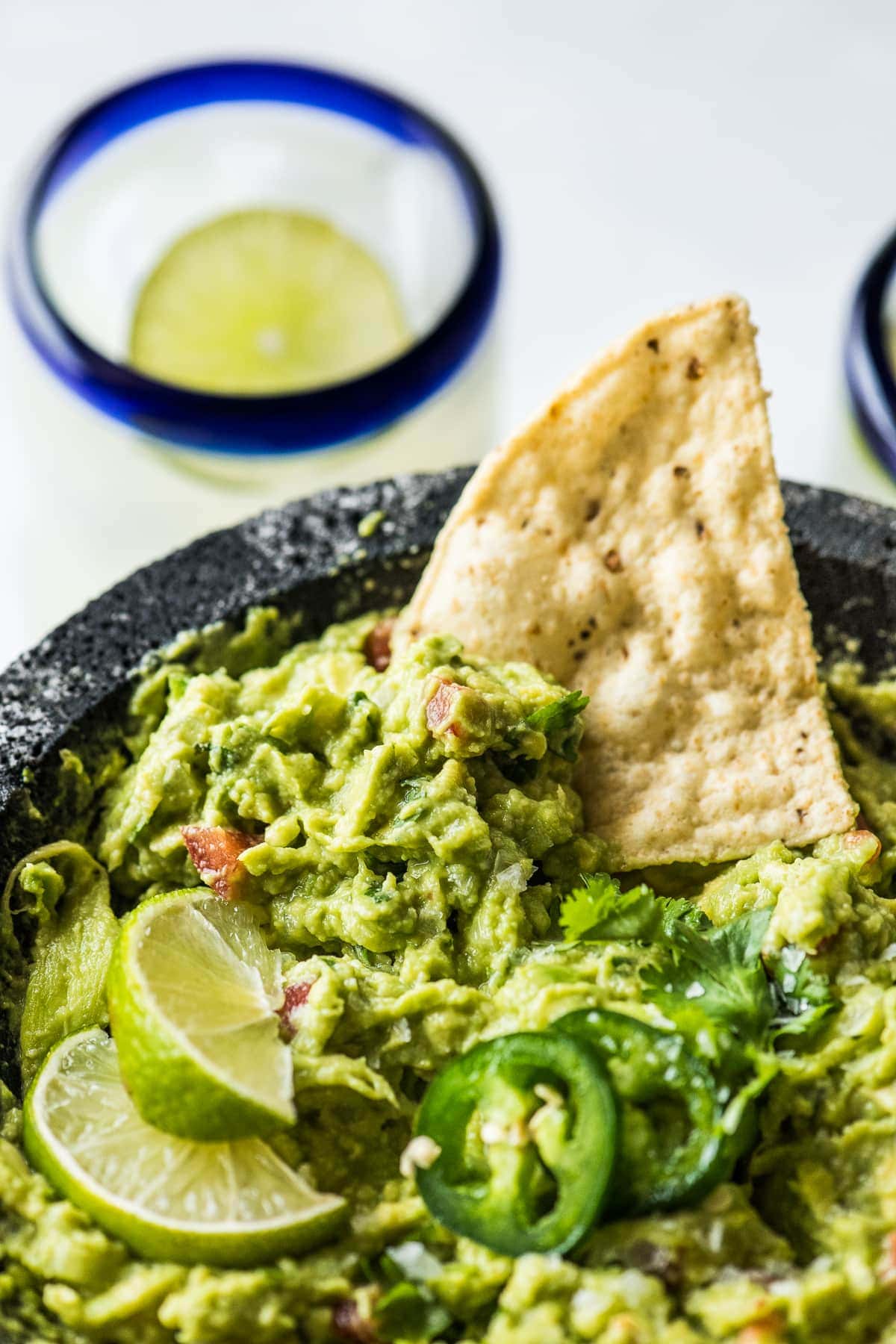 Guacamole in a molcajete with a tortilla chip.