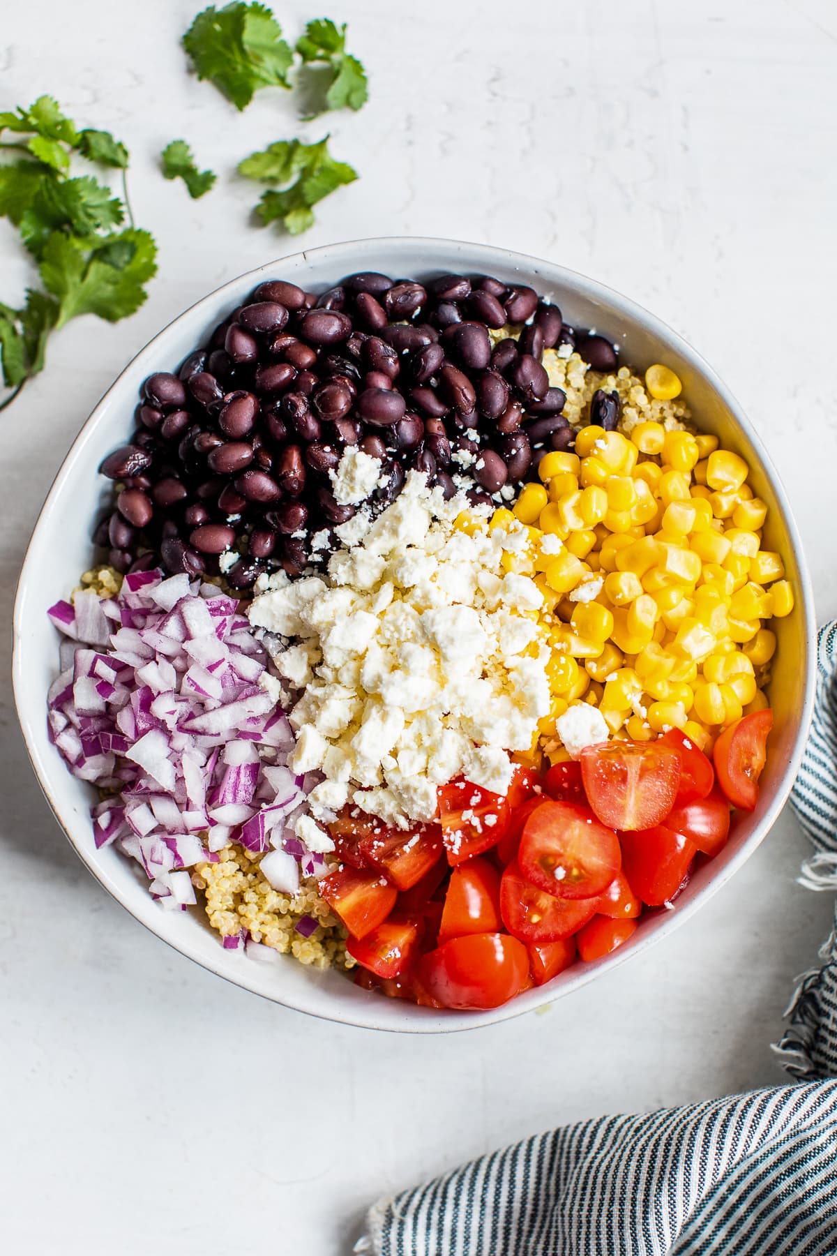 Ingredients for Mexican Quinoa Salad in a bowl before being mixed together.