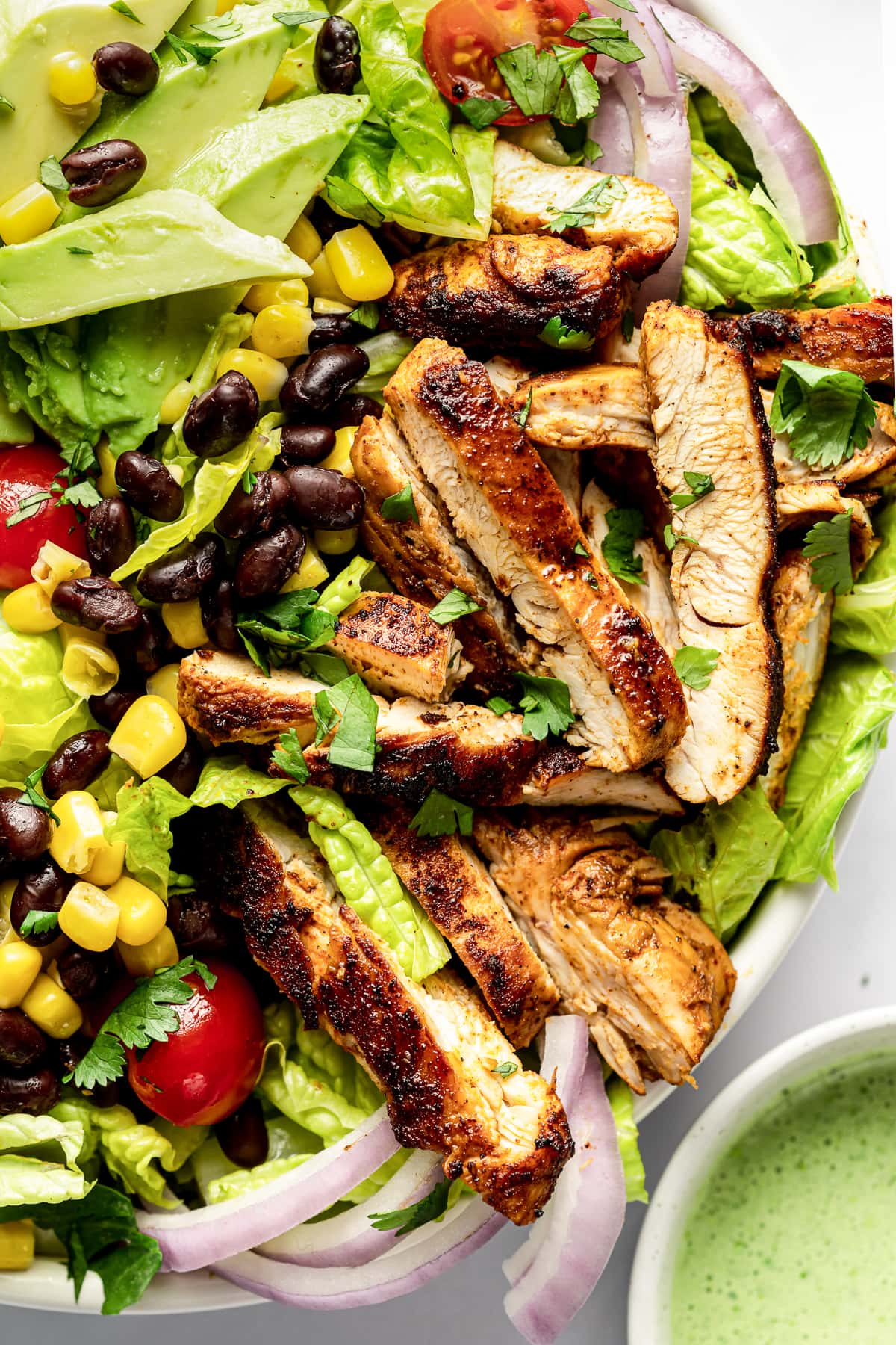 Southwest chicken salad topped with sliced marinated chicken, black beans, corn, and tomatoes.