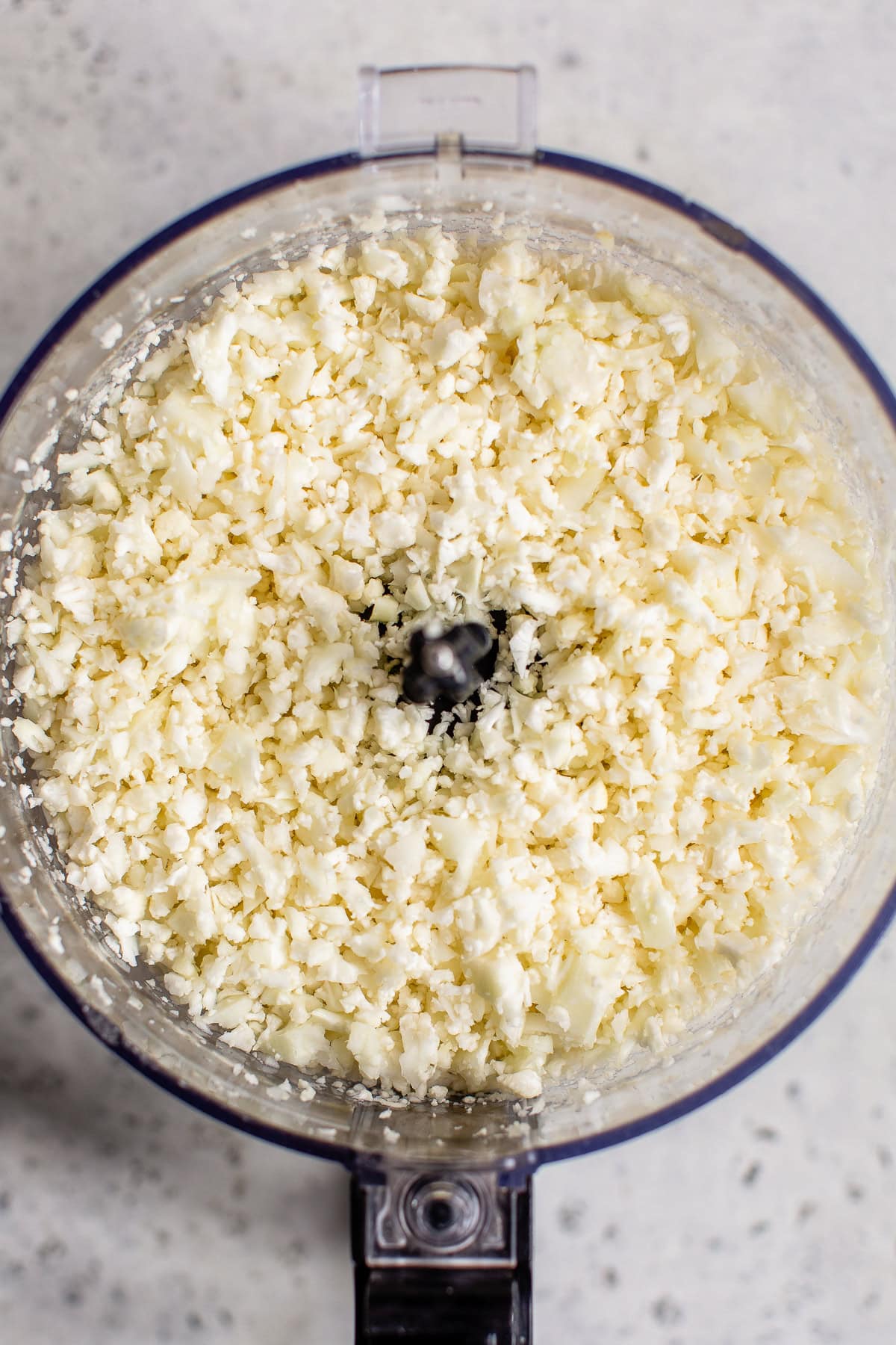 Cauliflower florets riced in a food processor.