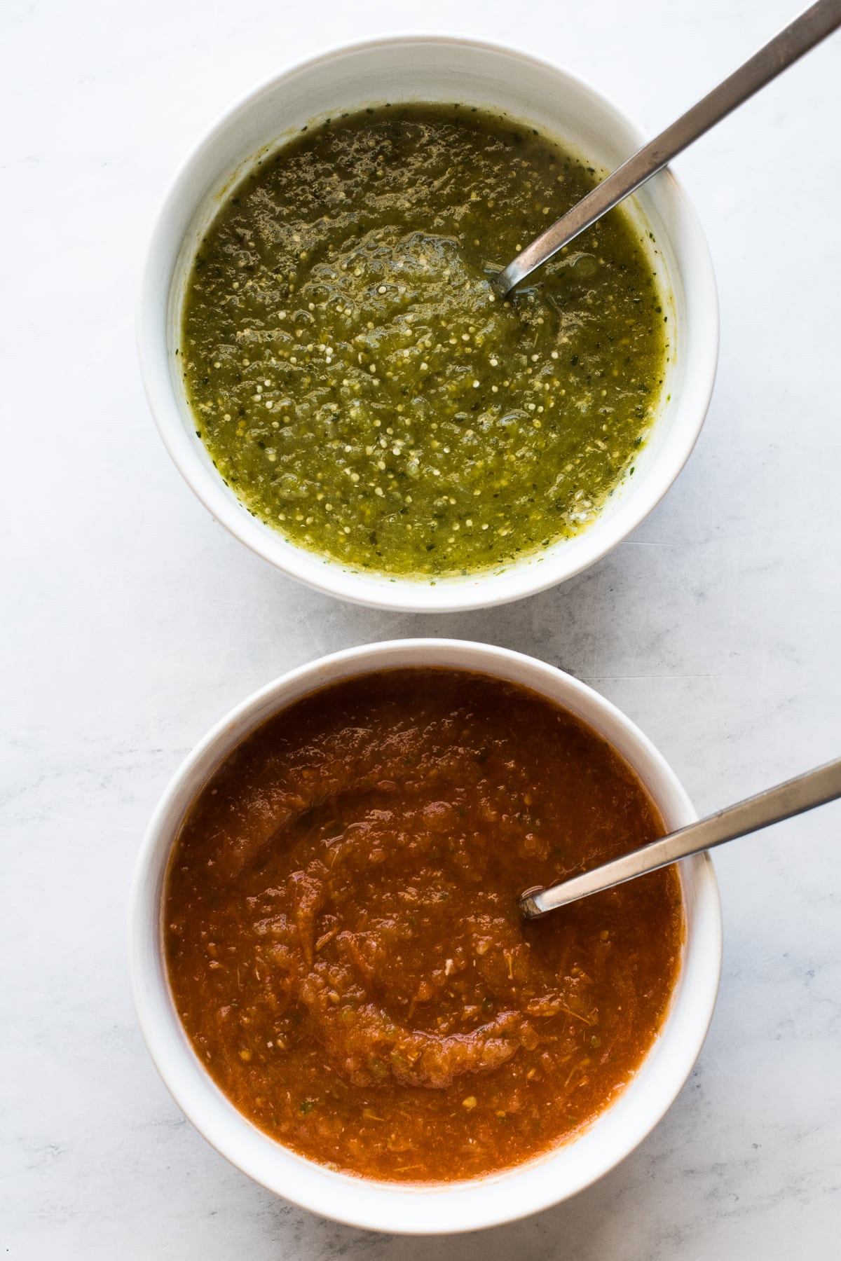 Salsa roja and salsa verde in bowls for huevos divorciados.