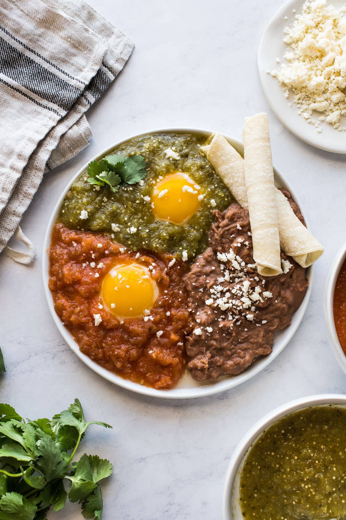 Huevos Divorciados on a plate served with refried beans.