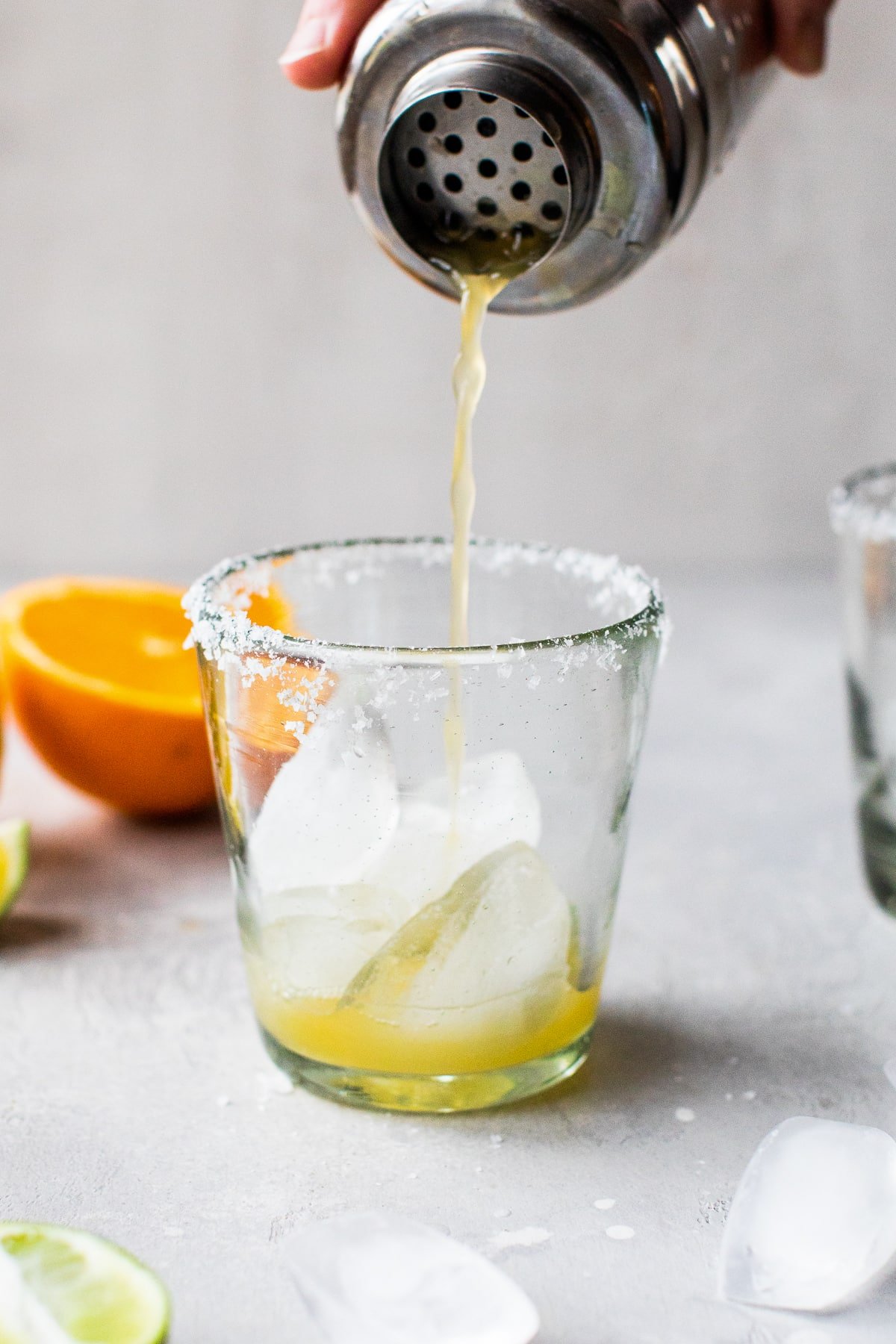 A virgin margarita being poured into a glass filled with ice.