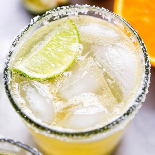 A classic virgin margarita cocktail in a glass with ice and a lime wedge.