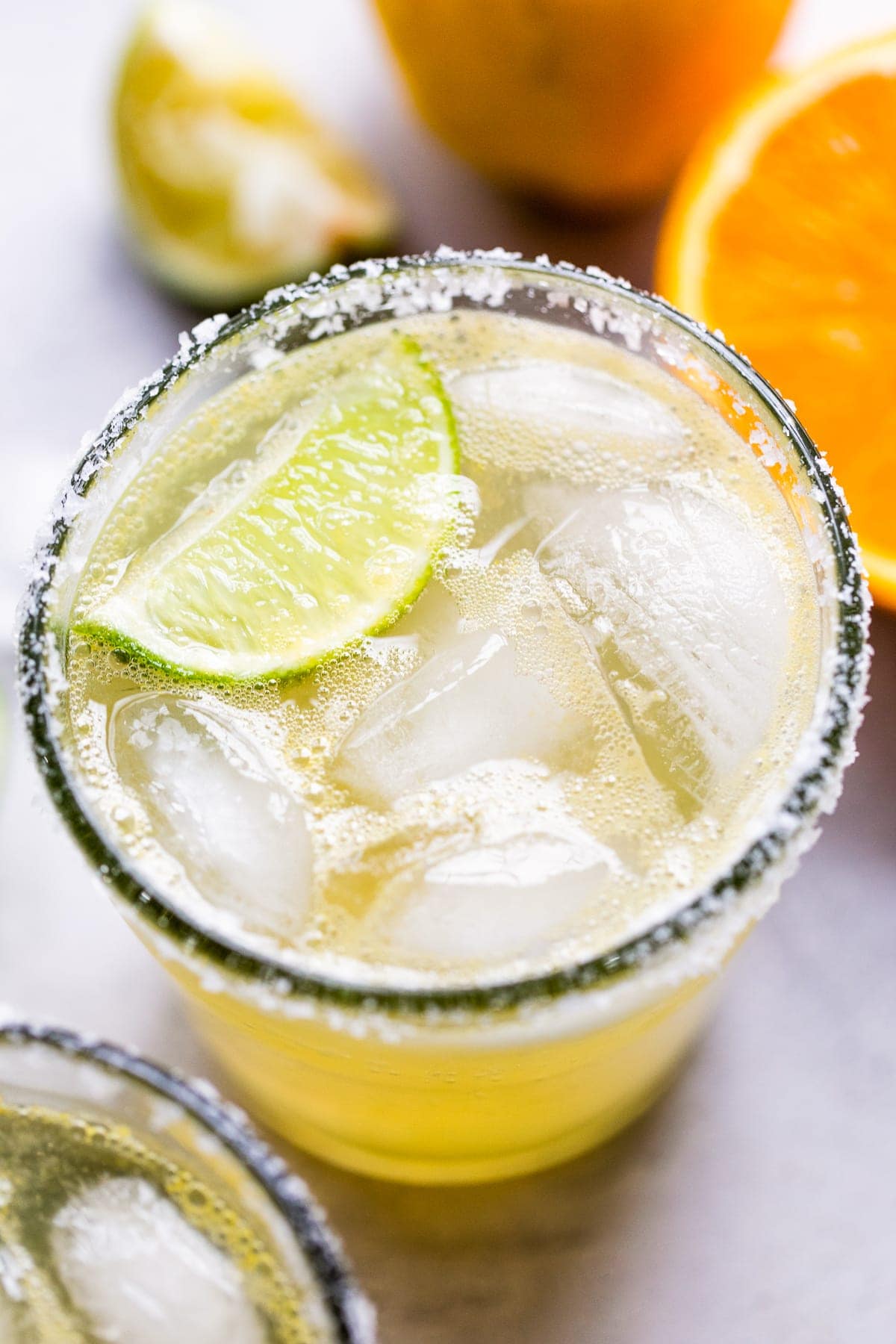 A classic virgin margarita cocktail in a glass with ice and a lime wedge.