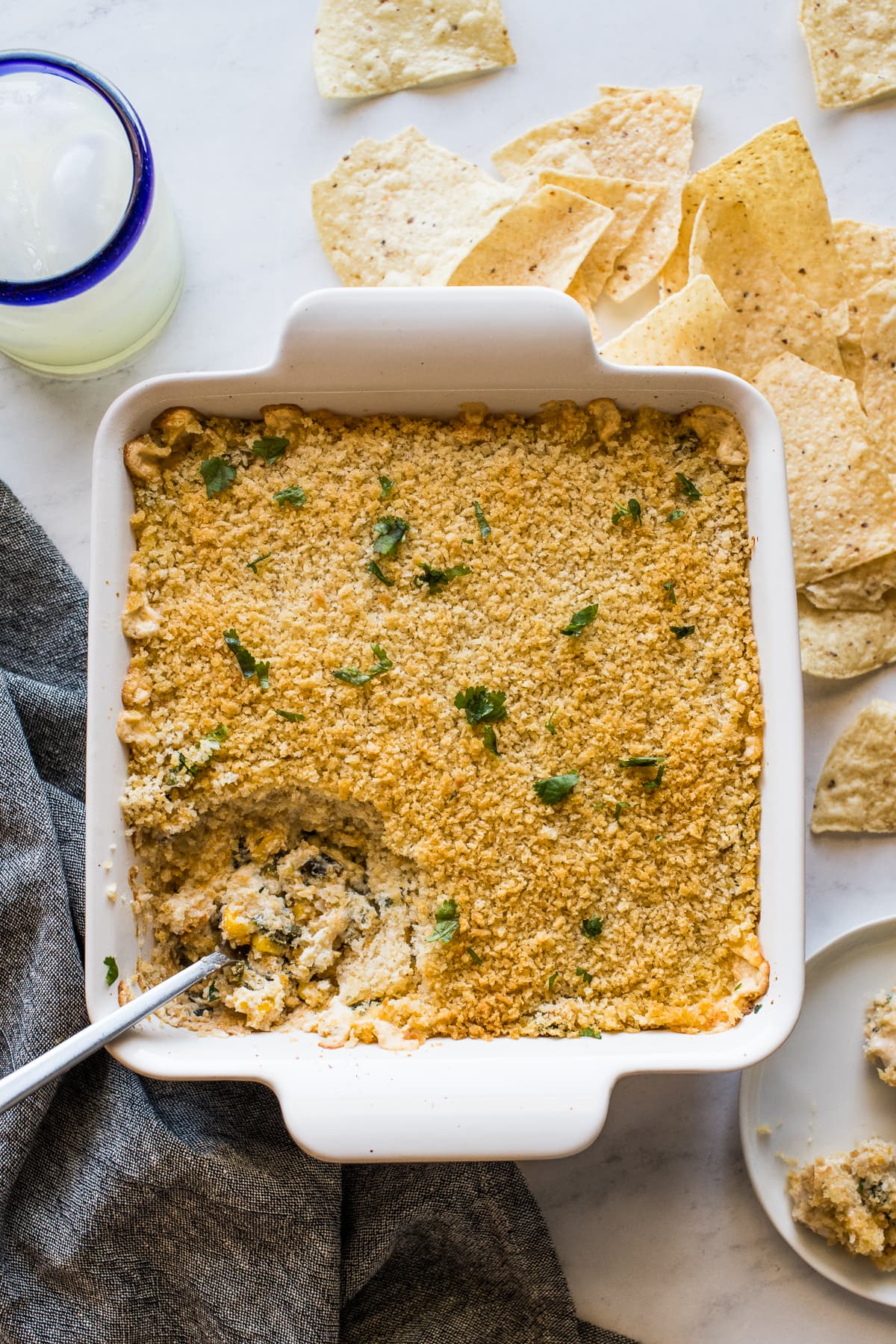 Chile relleno dip in a baking dish surrounded by tortilla chips.