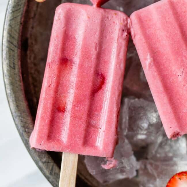 Frozen strawberry paletas on ice.