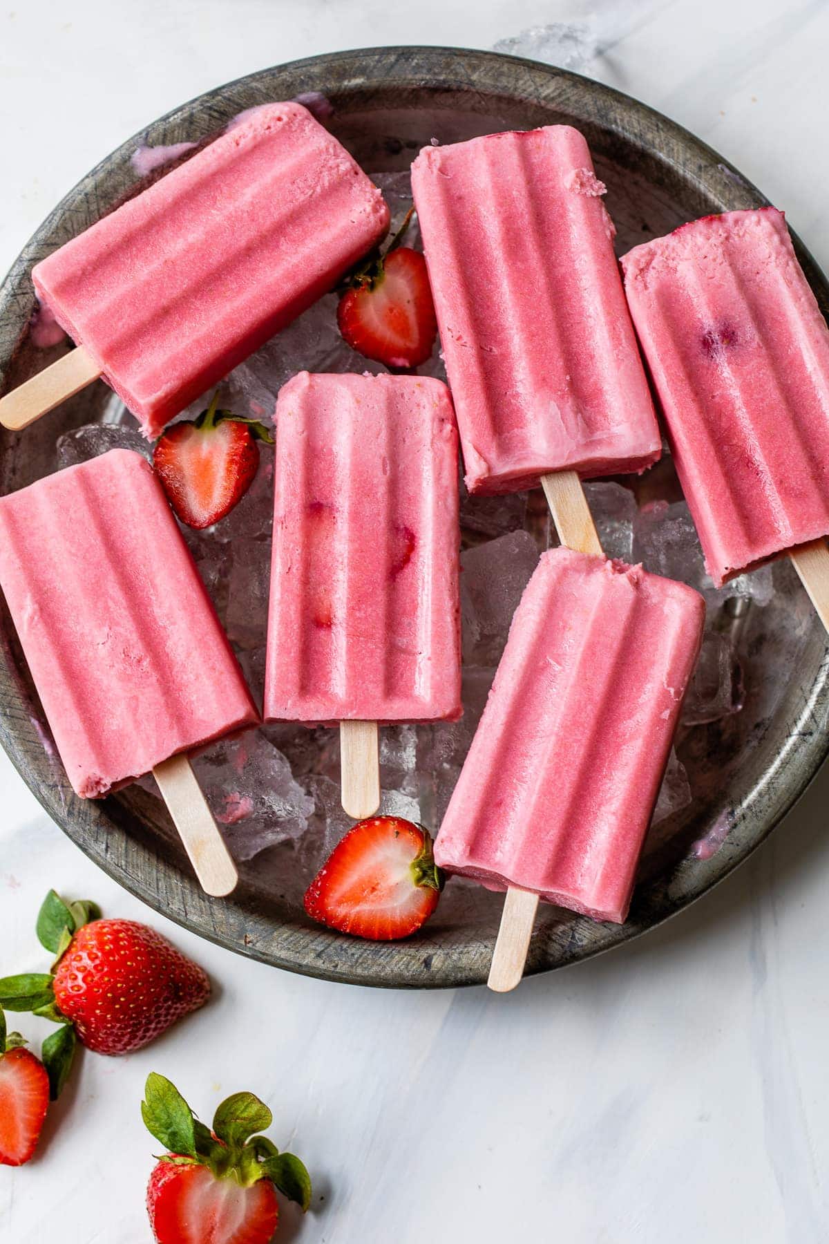 Strawberries and cream popsicles ready to be eaten.