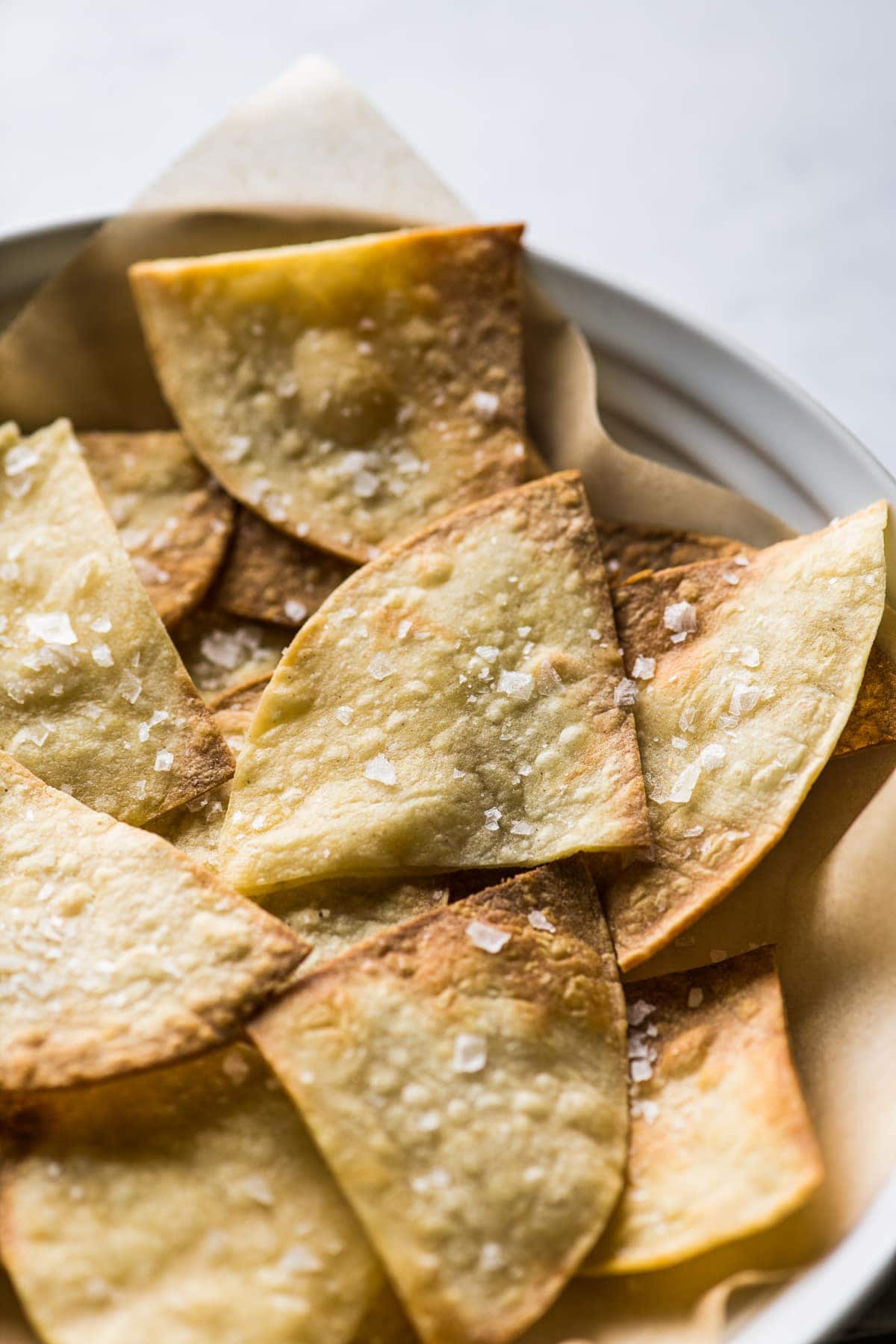 Air fryer tortilla chips seasoned with flaky sea salt.