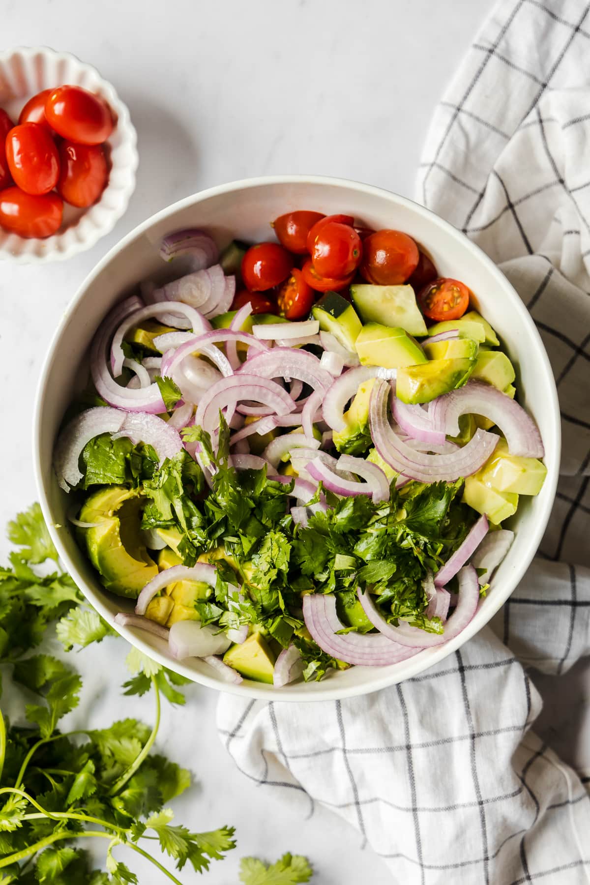 Ingredients for avocado salad in a large mixing bowl.