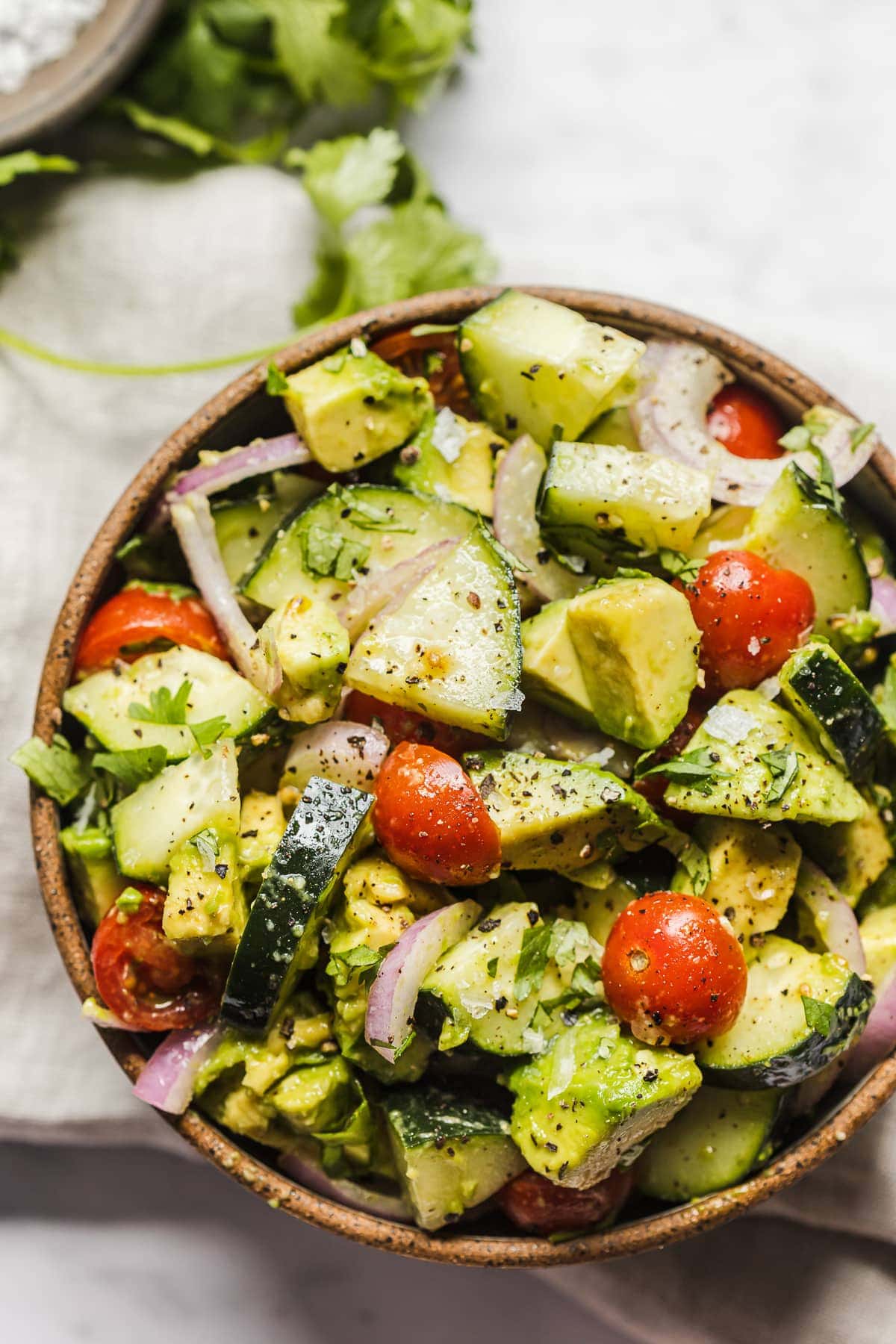 A bowl of avocado salad with cucumbers.