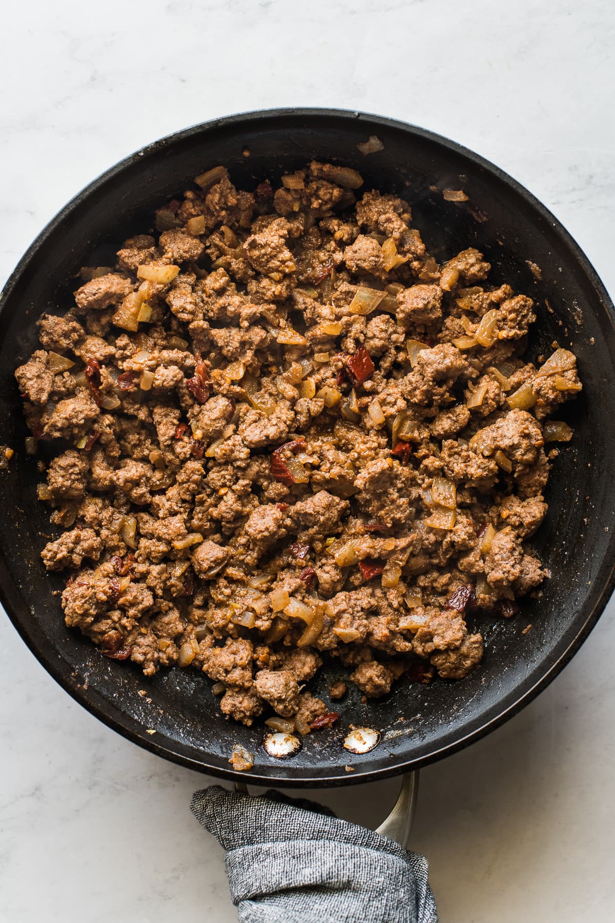 Ground beef mixture for beef taquitos in a skillet.