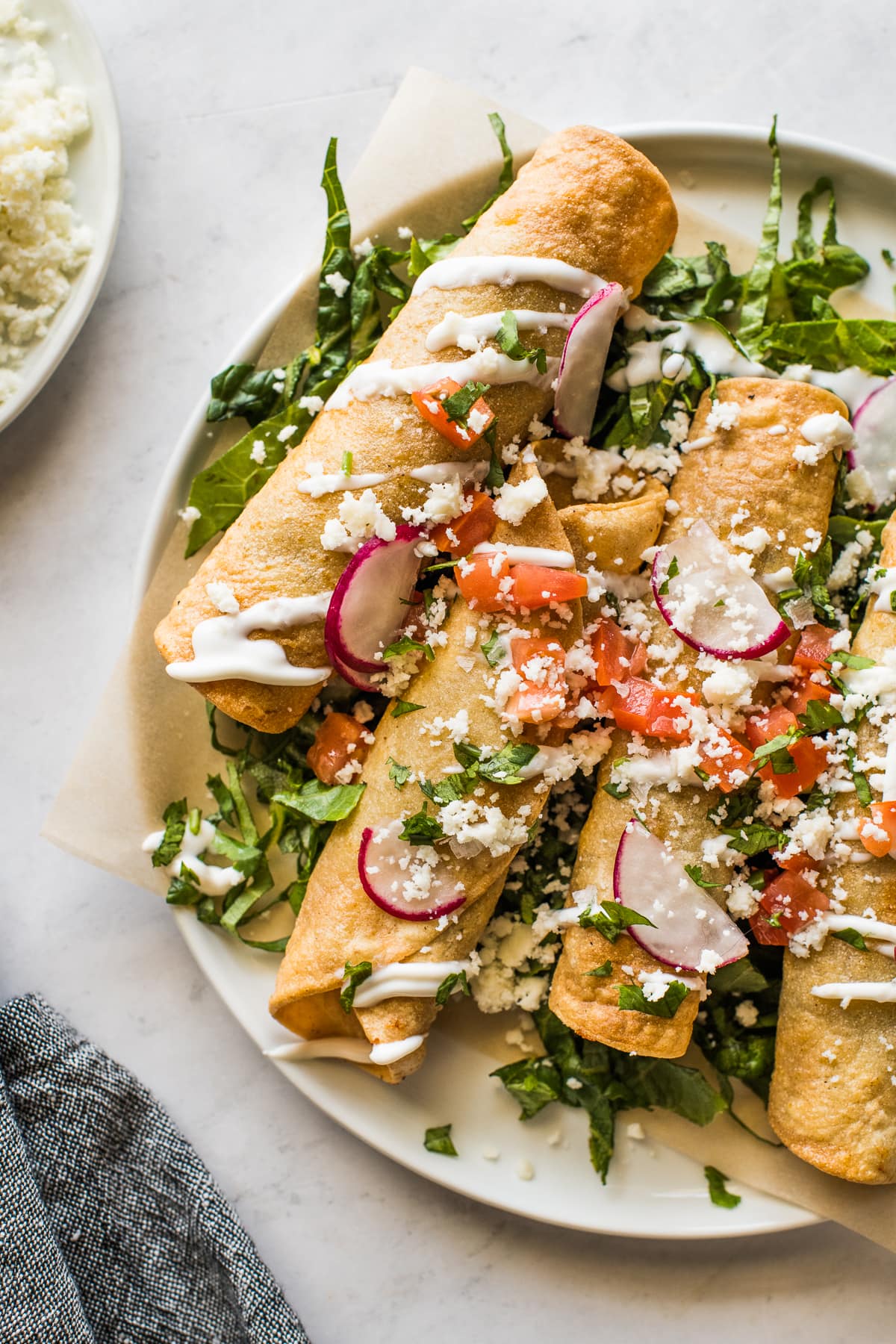 Beef taquitos on a bed of shredded lettuce.