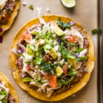 Chicken Tostadas topped with cilantro, cheese, and avocado.