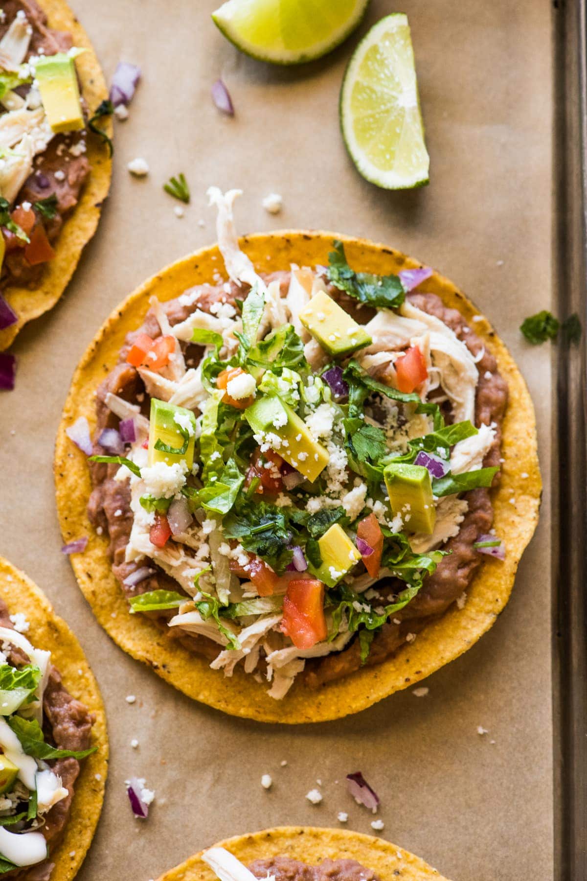 Chicken Tostadas topped with cilantro, cheese, and avocado.