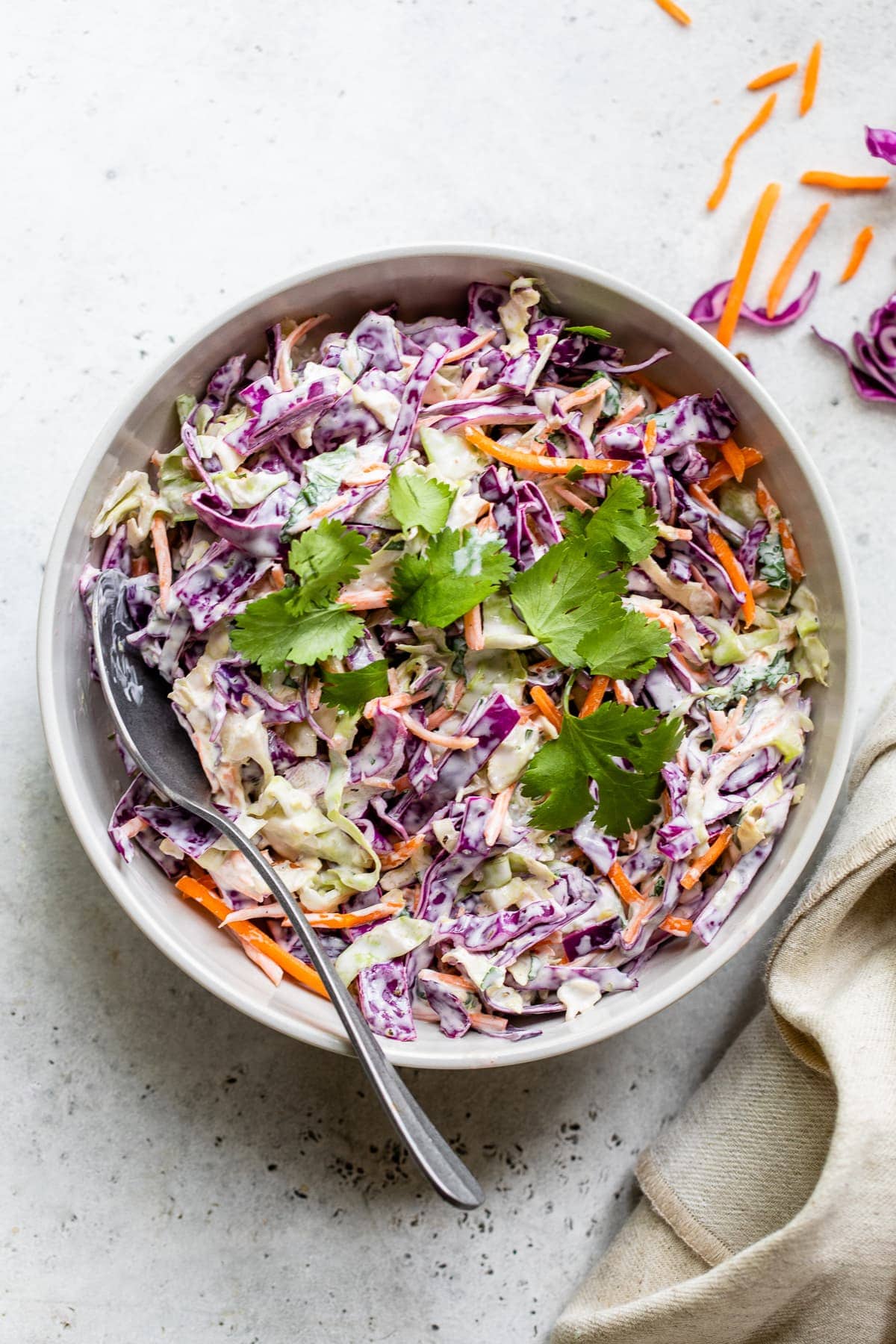 Fish taco slaw in a bowl topped with cilantro leaves.