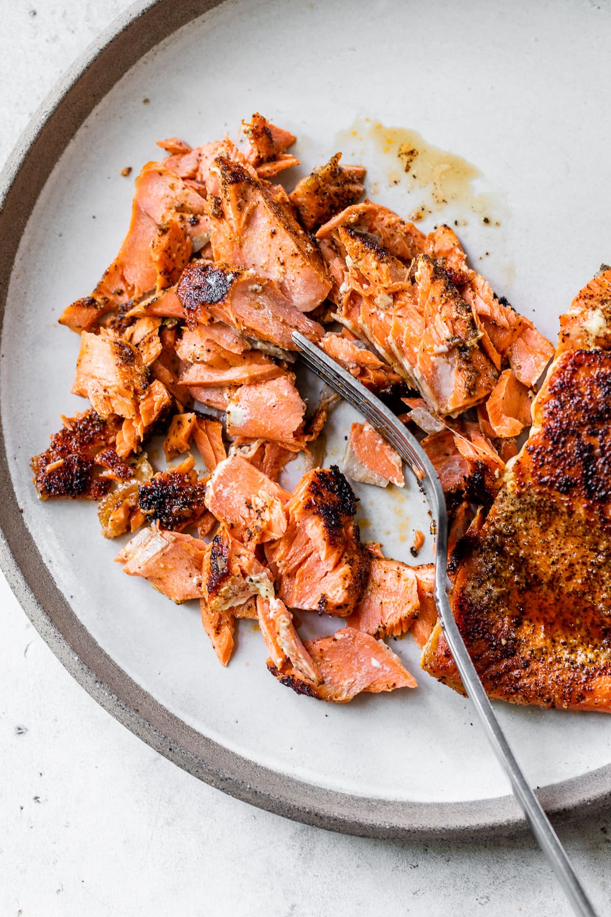 Cooked salmon that has been flaked into pieces with a fork.