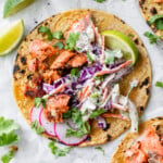 Salmon tacos topped with a creamy slaw and fresh cilantro.