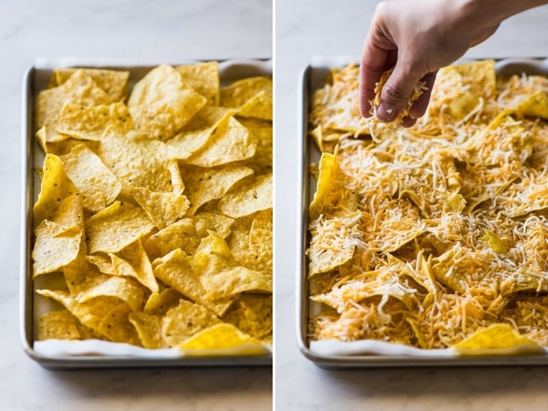 Shredded cheese being sprinkled on top of tortilla chips.