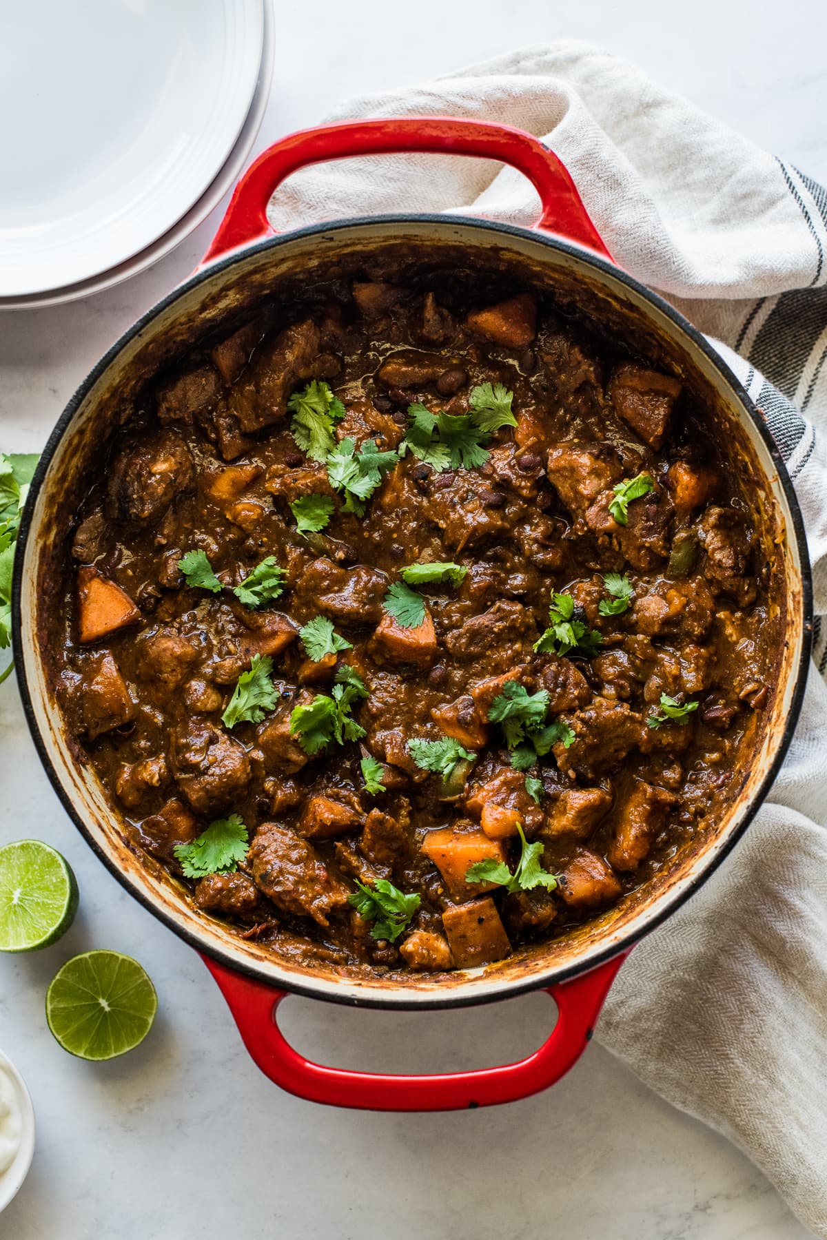 Pork chili in a dutch oven garnished with cilantro.