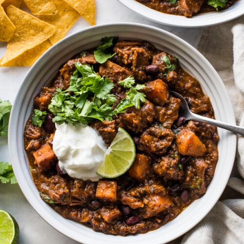 Pork chili in a bowl made from beans, sweet potatoes, pork shoulder, and chipotle spices.