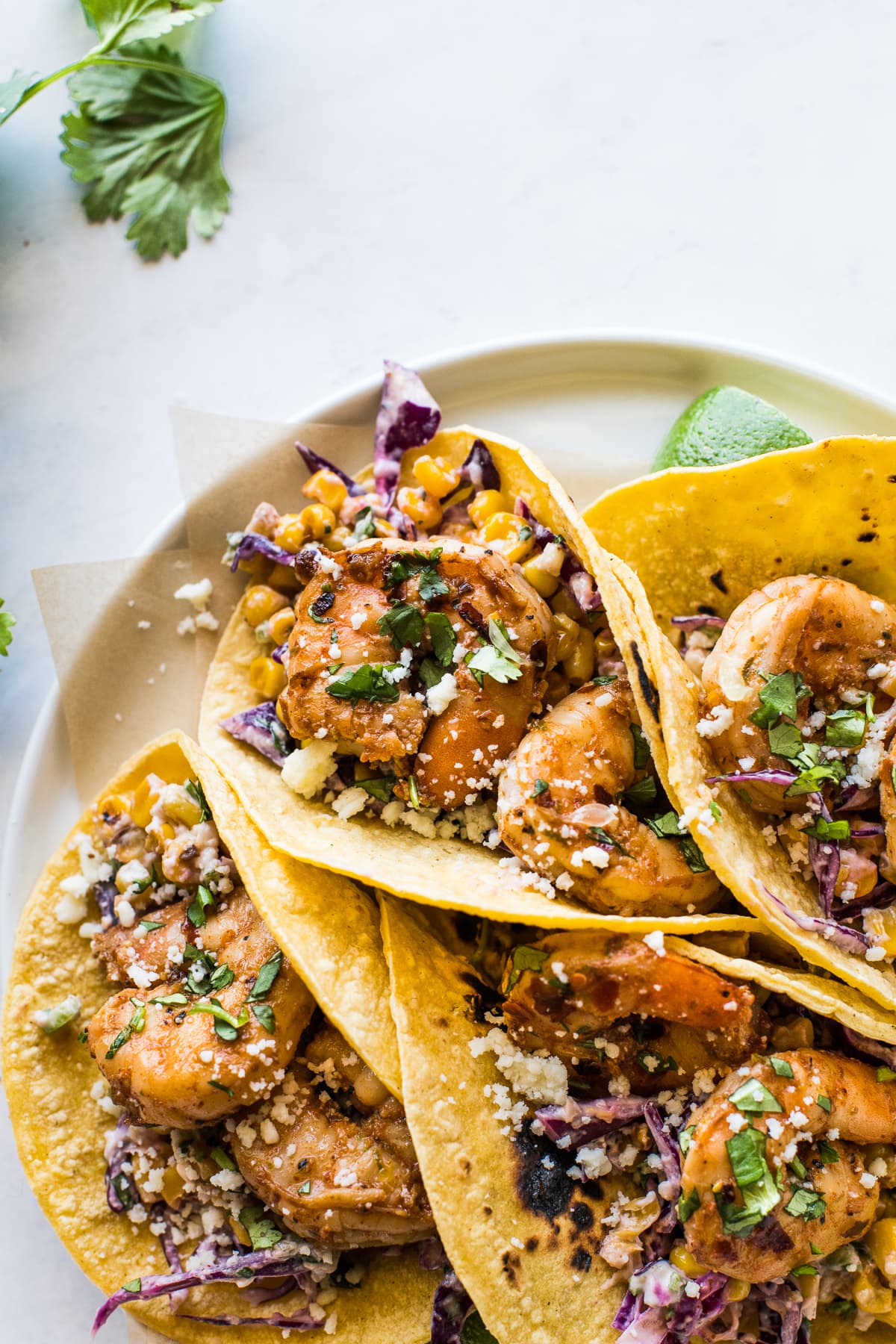 Shrimp tacos topped with cilantro and cotija cheese.