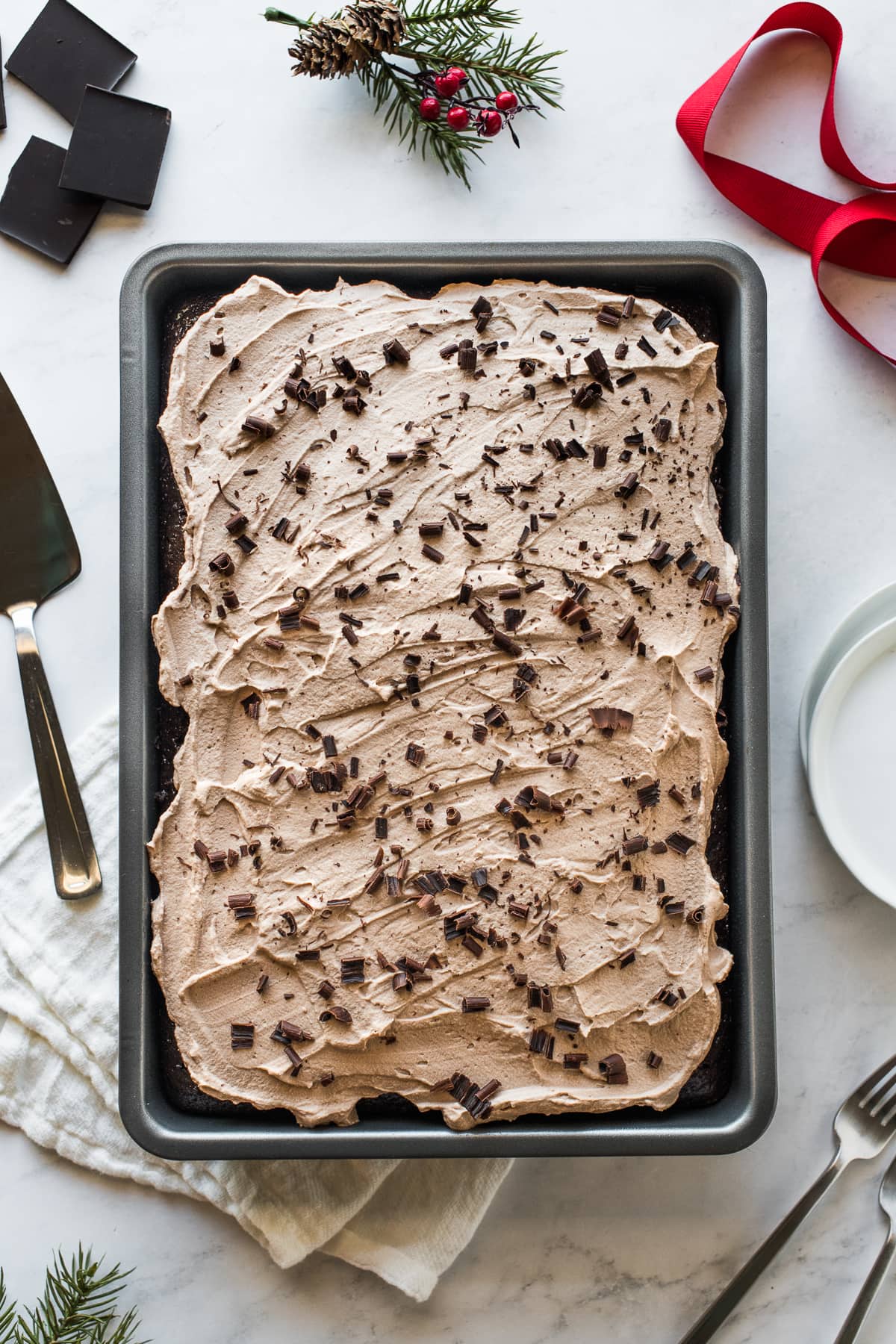 Chocolate tres leches cake in a baking dish topped with chocolate shavings.