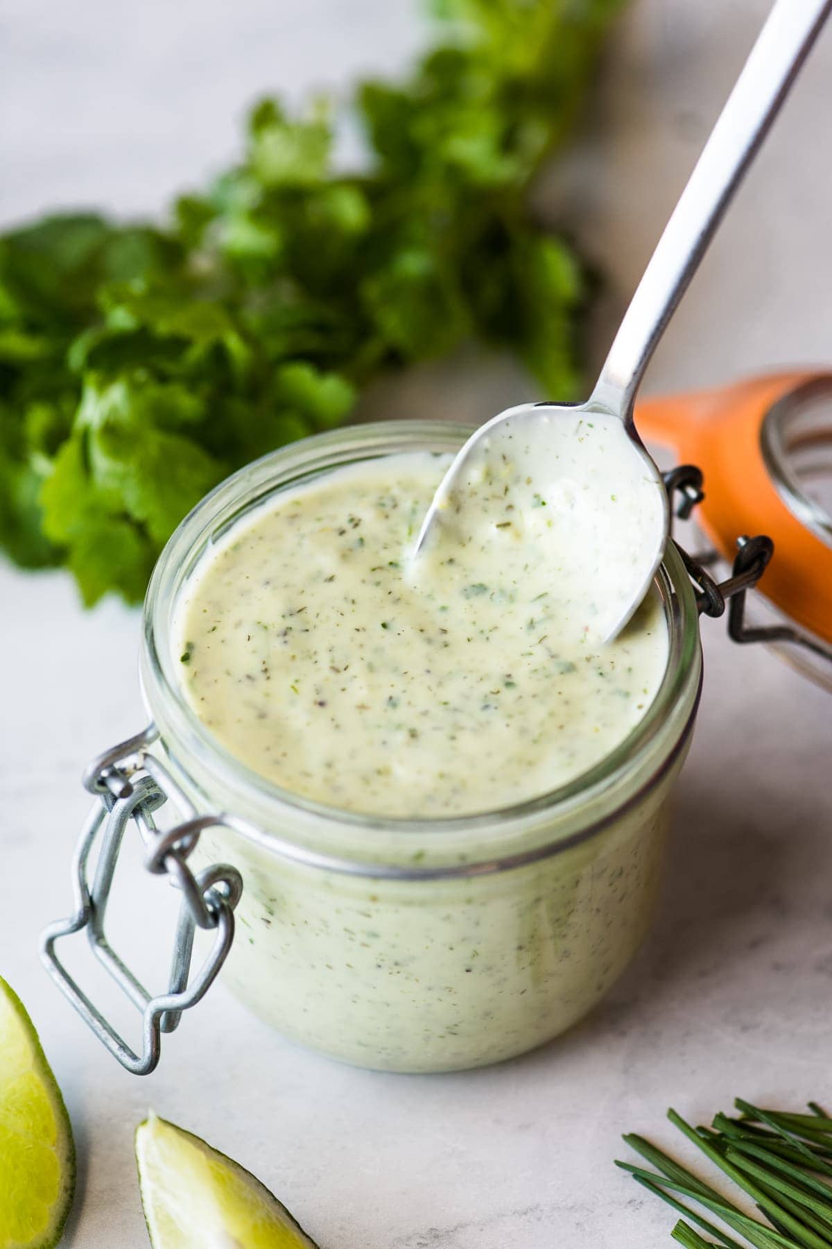 A spoon stirring jalapeno ranch in a jar.