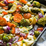 Roasted vegetables on a sheet pan topped with cilantro and cotija cheese.