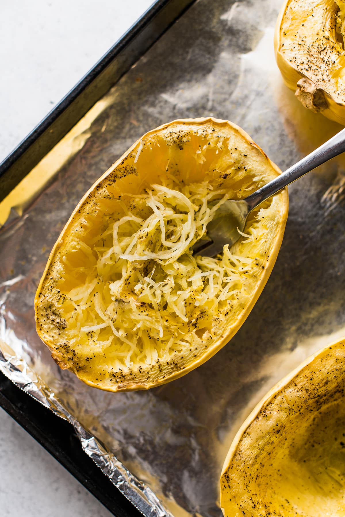 Roasted spaghetti squash on a baking sheet.