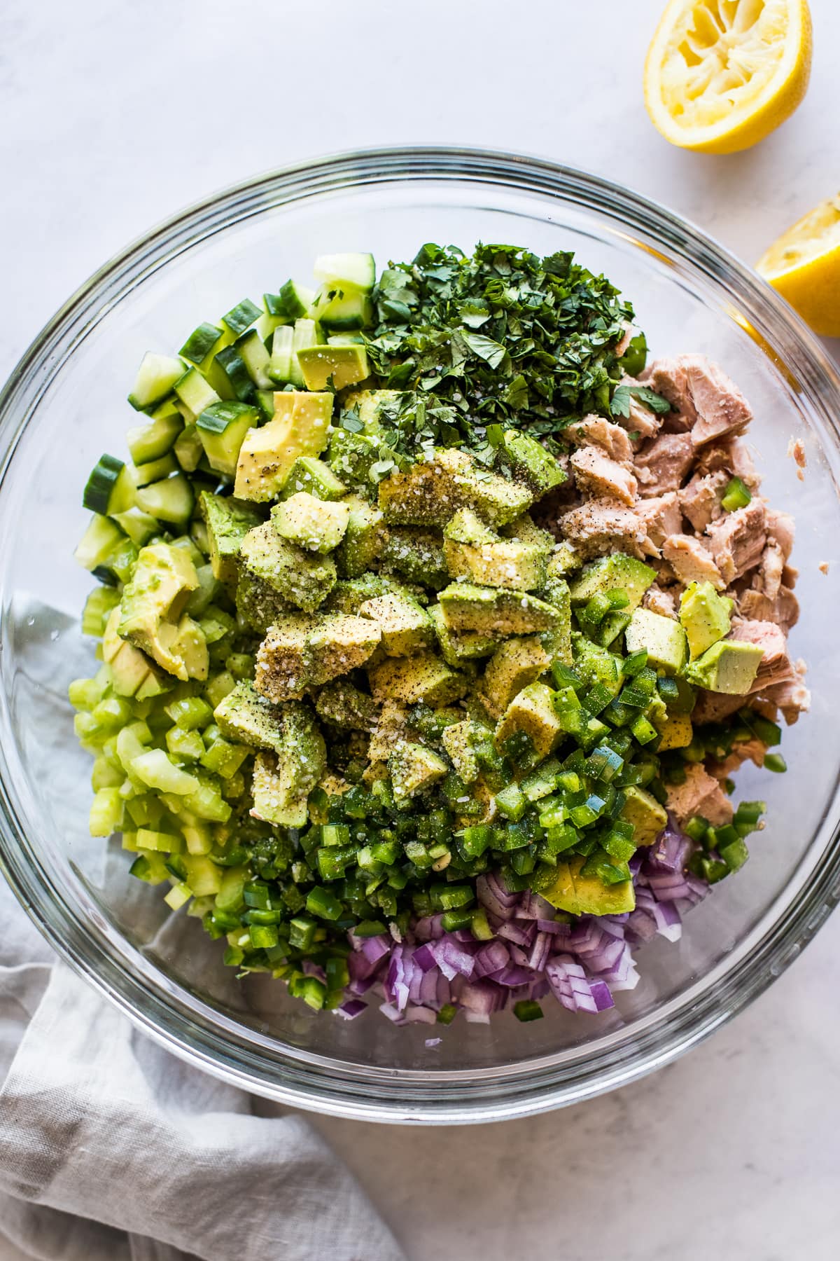 Avocado tuna salad ingredients in a bowl ready to be mixed together.