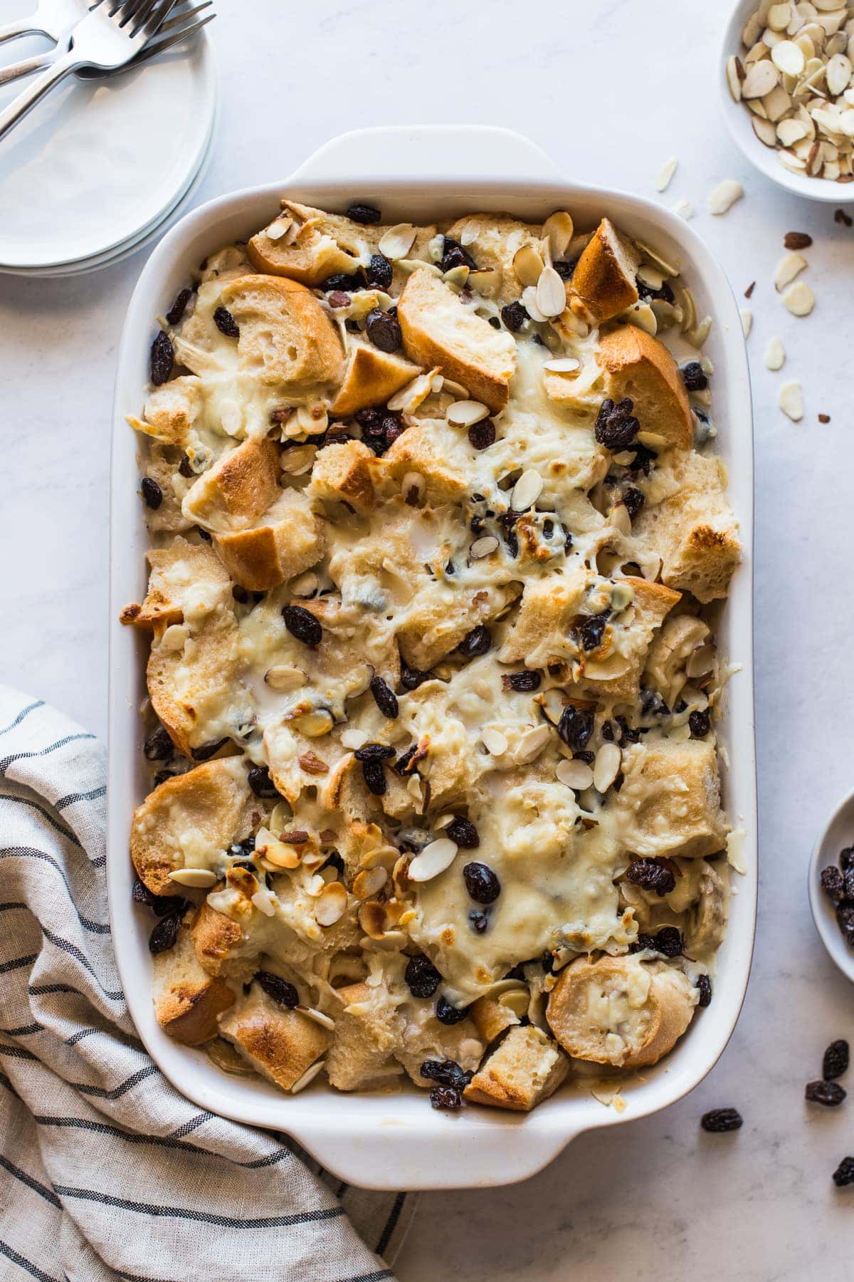 Capirotada (or Mexican Bread Pudding) in a baking dish topped with raisins and cheese.