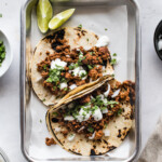 Chorizo tacos topped with lime crema and cilantro.