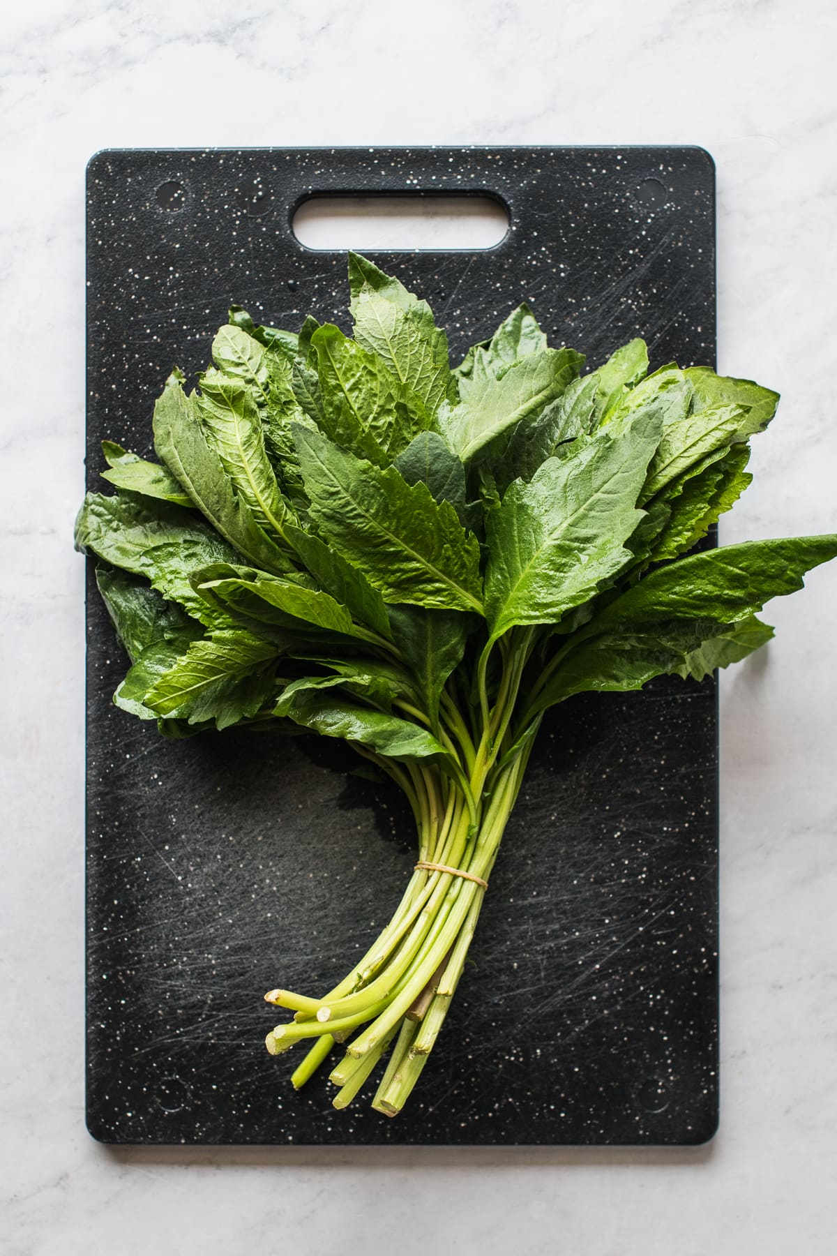 A bunch of fresh epazote on a cutting board.