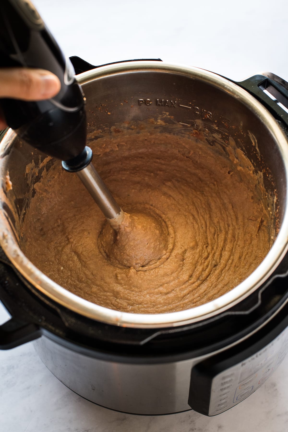 Refried beans in the Instant Pot being blended.