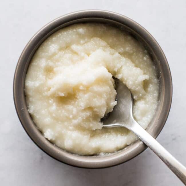 Lard in a small bowl with a spoon.