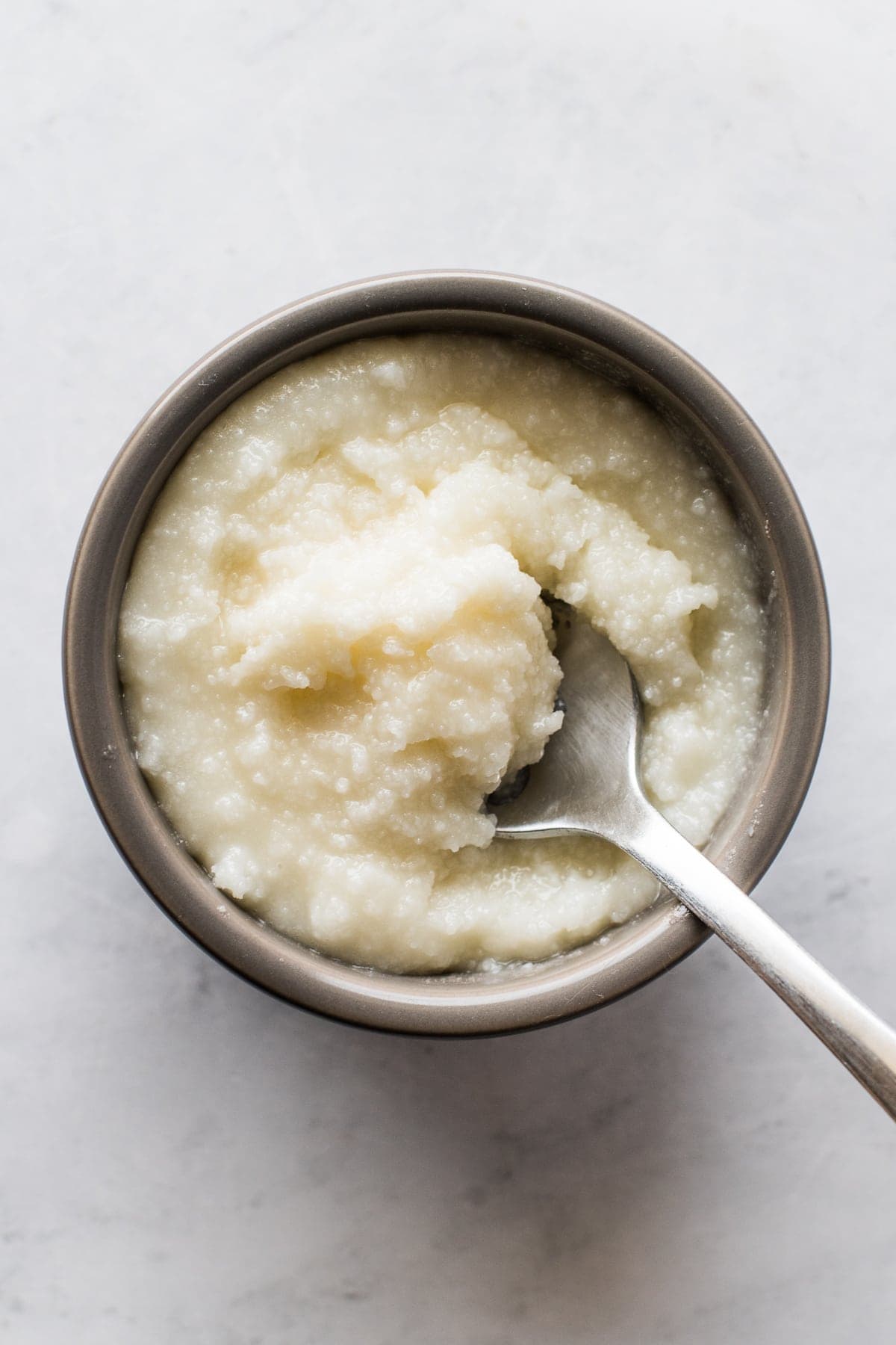 Lard in a small bowl with a spoon.