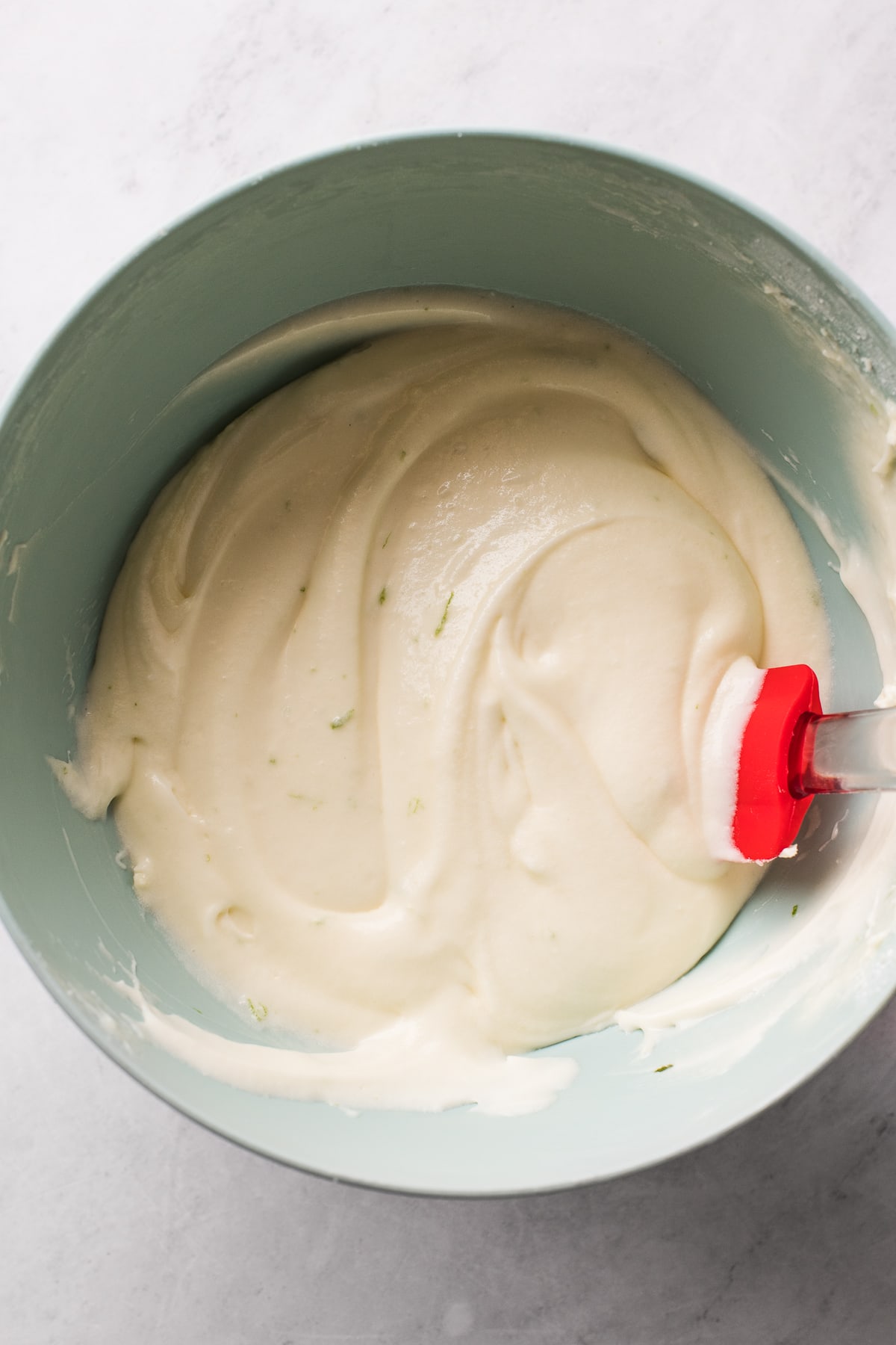 A bowl of lime cream cheese frosting.