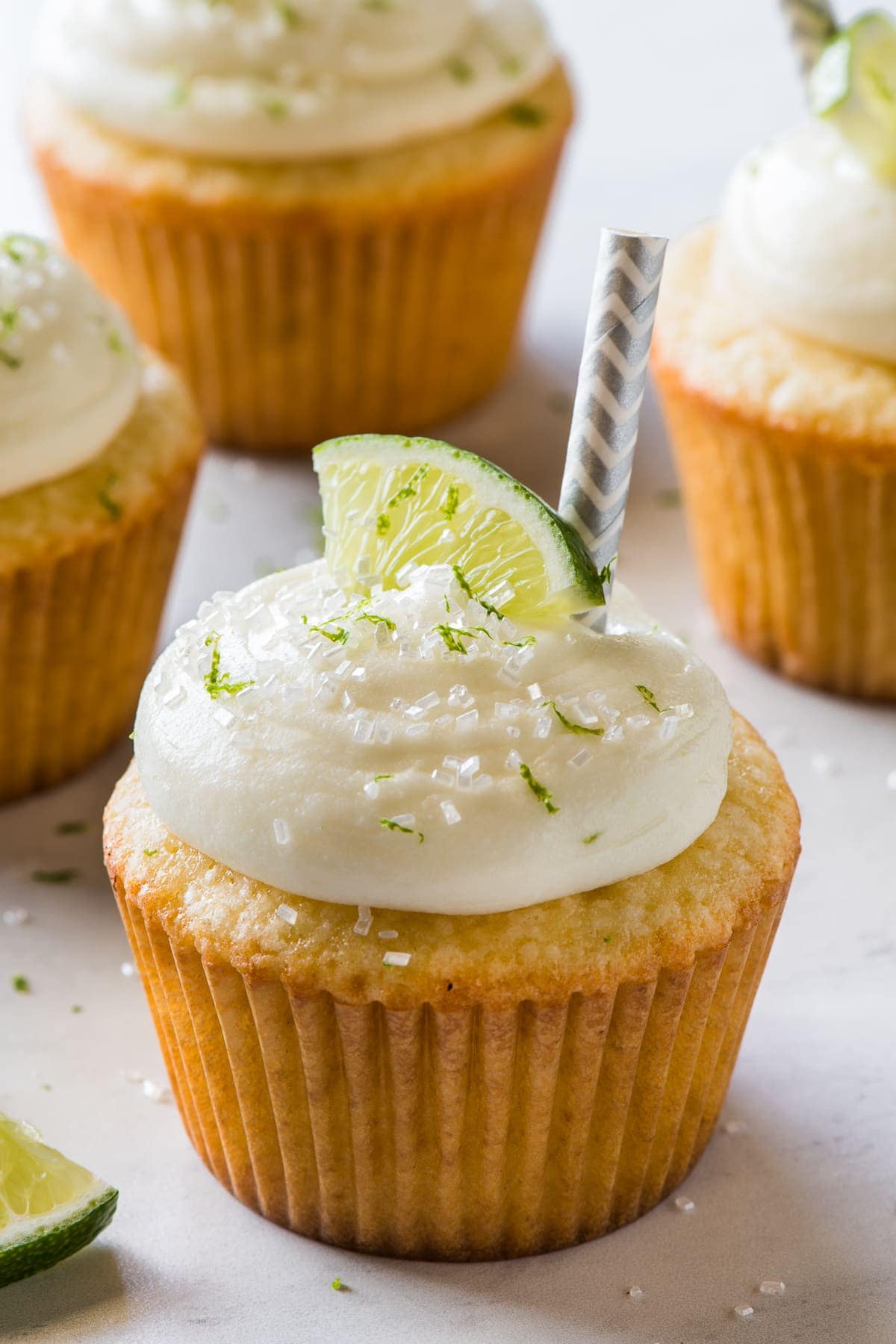 A Margarita Cupcake topped with cream cheese frosting, lime zest, and sprinkles.