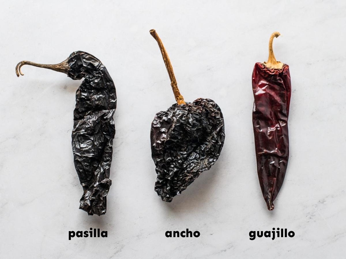 Pasilla pepper next to ancho and guajillo peppers.